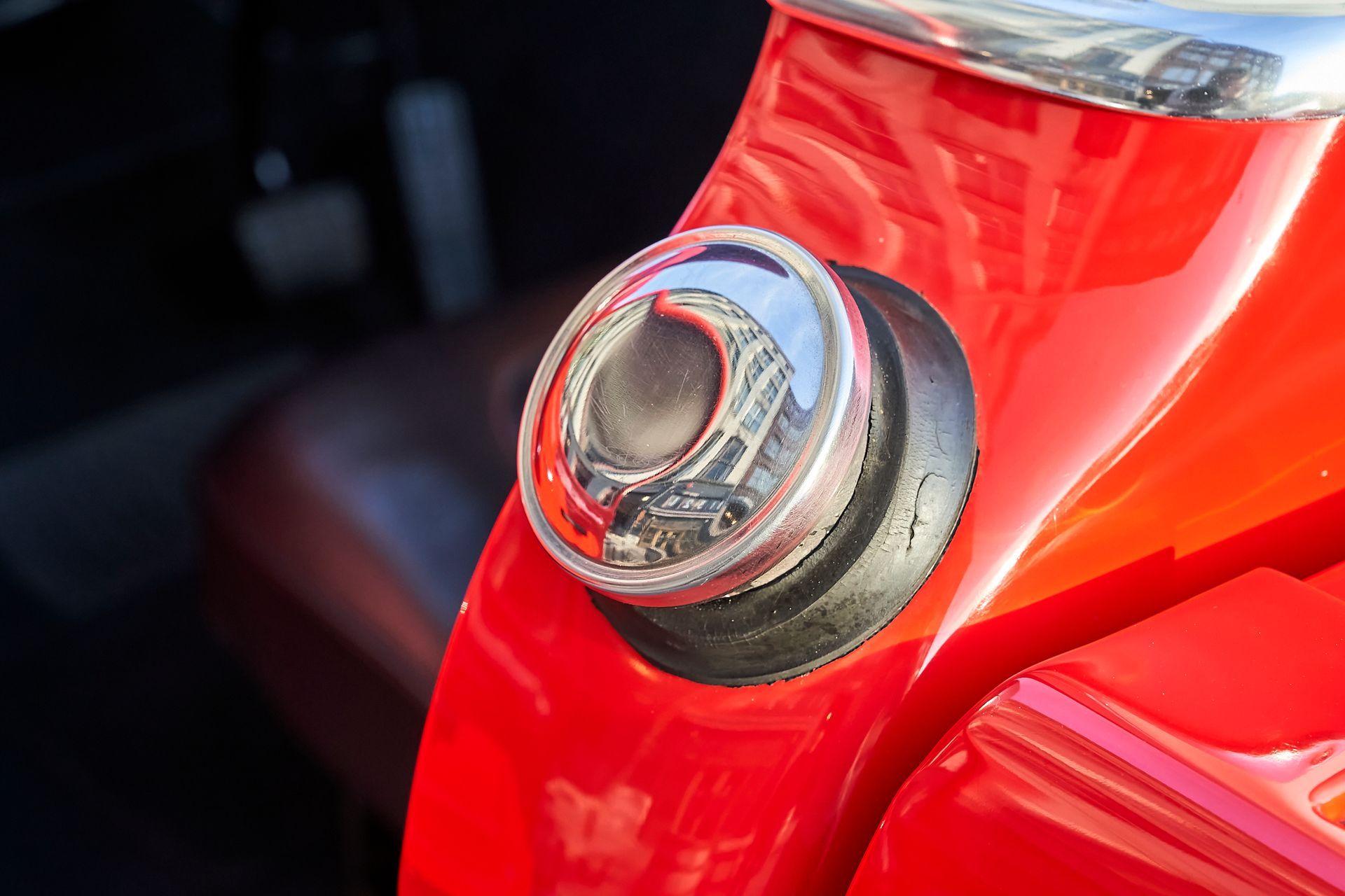A close up of a red car with a chrome fuel cap