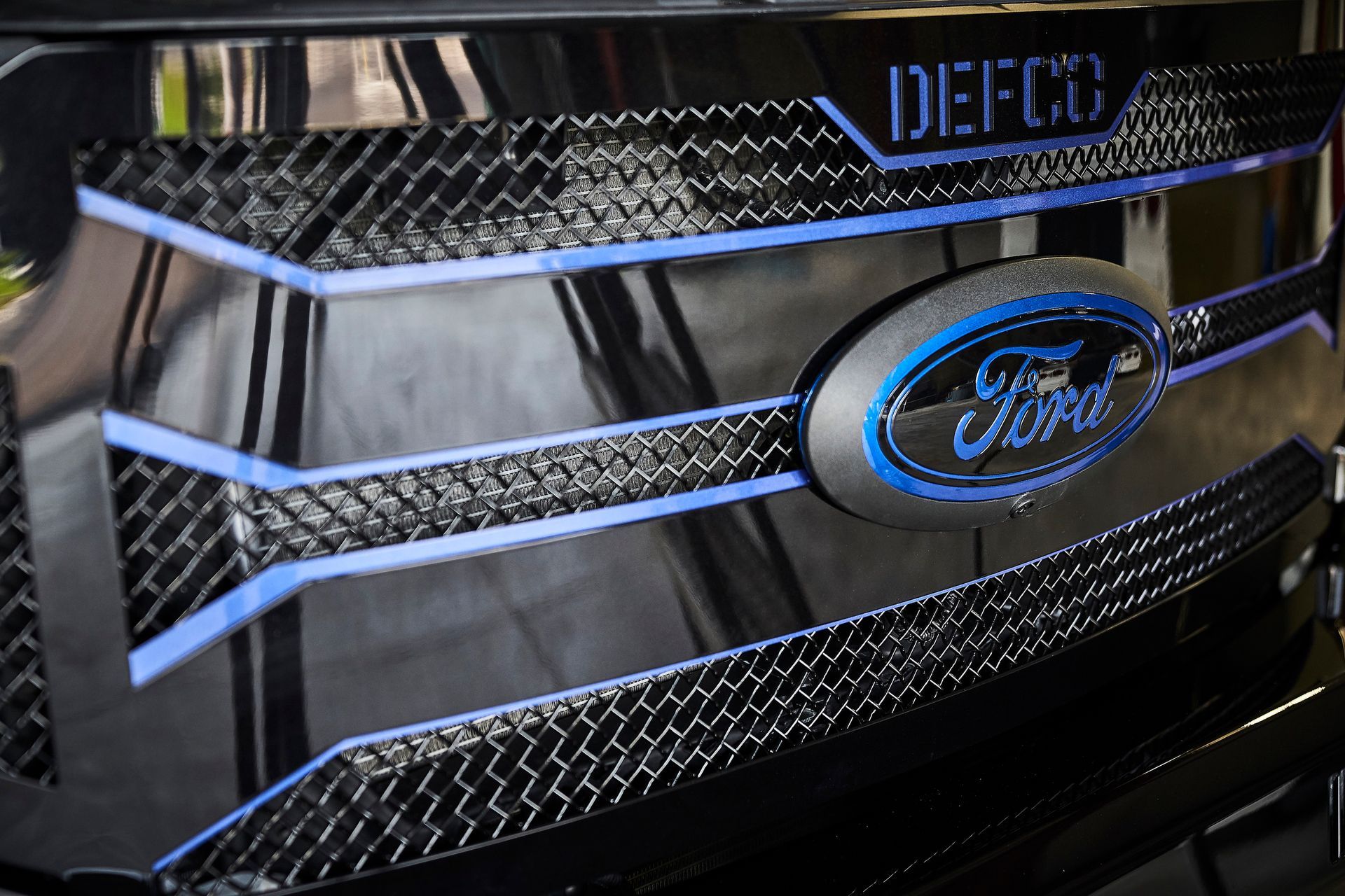 A close up of a ford logo on the front of a car
