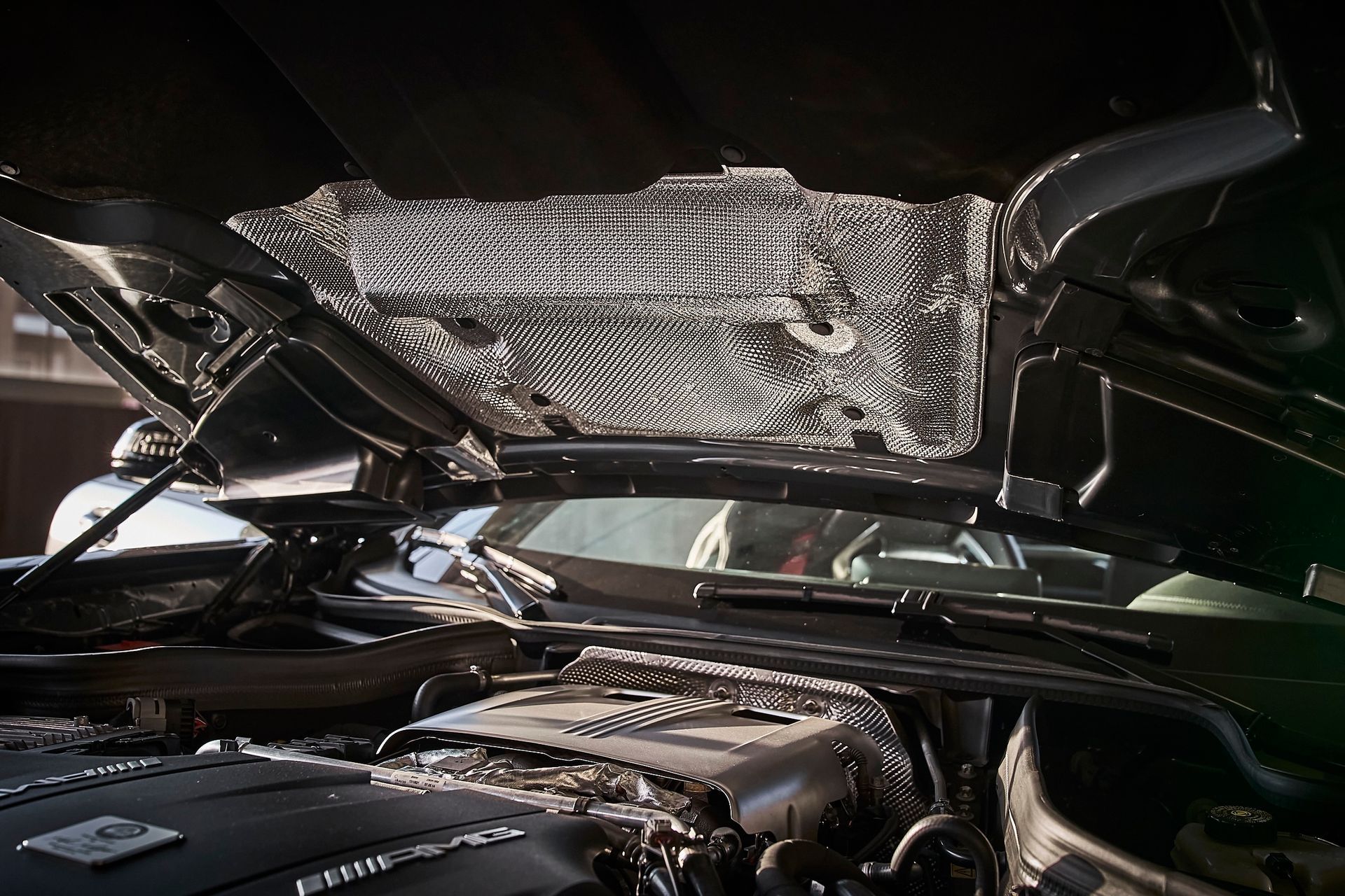 The hood of a car is open and the engine is visible.