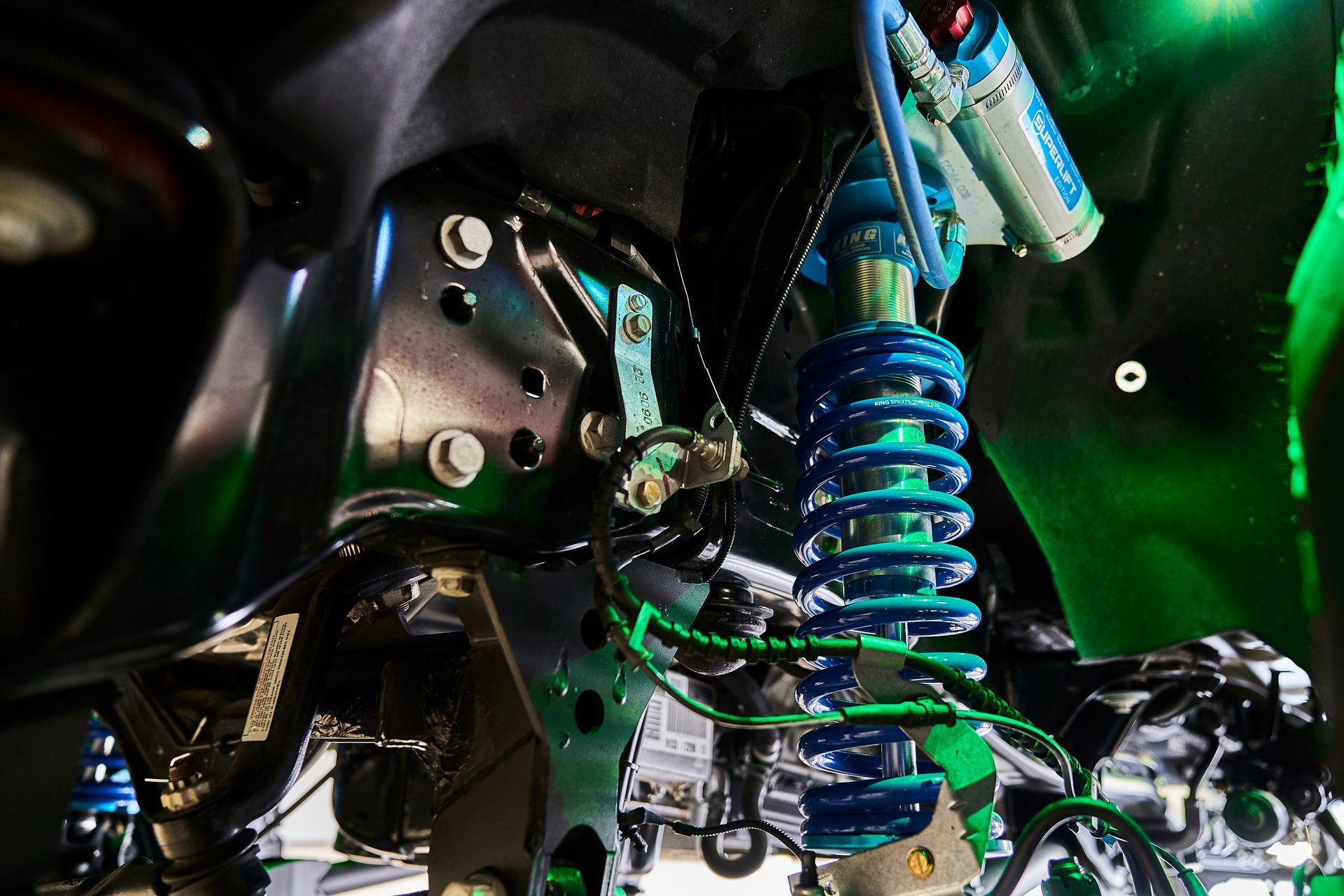 A close up of a car suspension with a green background