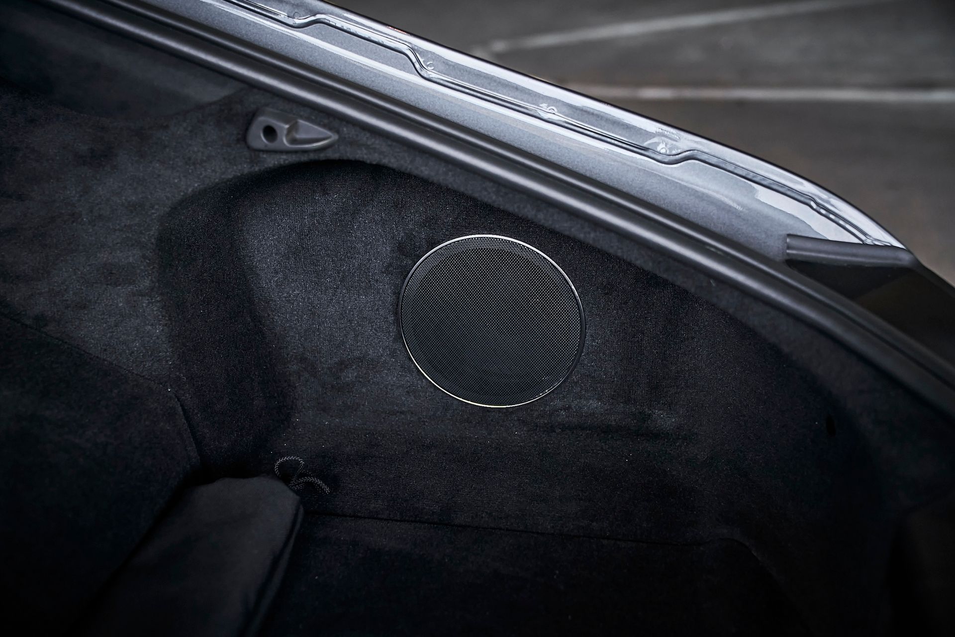 A close up of a speaker in the back of a car.