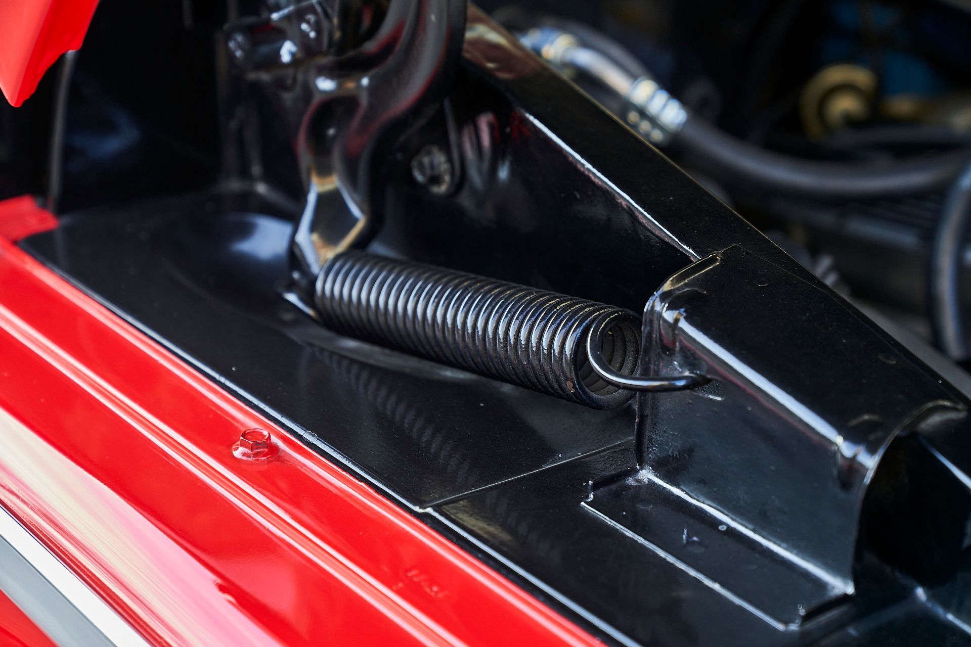 A close up of a spring on a red car