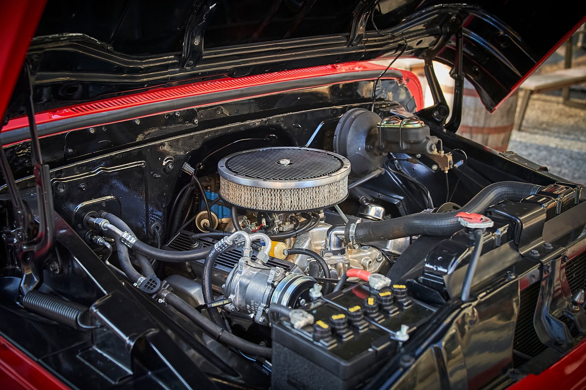 A close up of a car engine with the hood open.