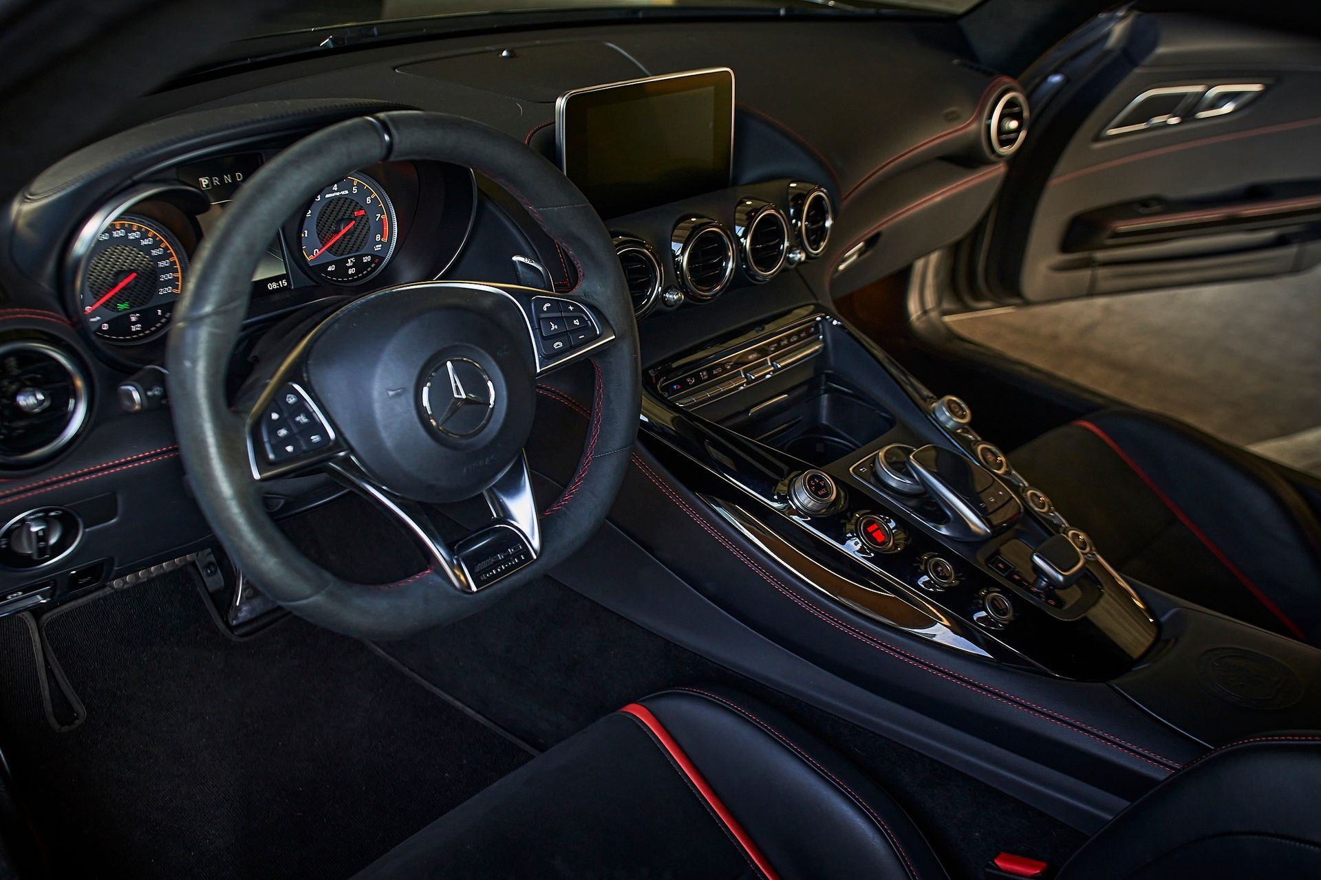 The interior of a sports car with a steering wheel and dashboard.