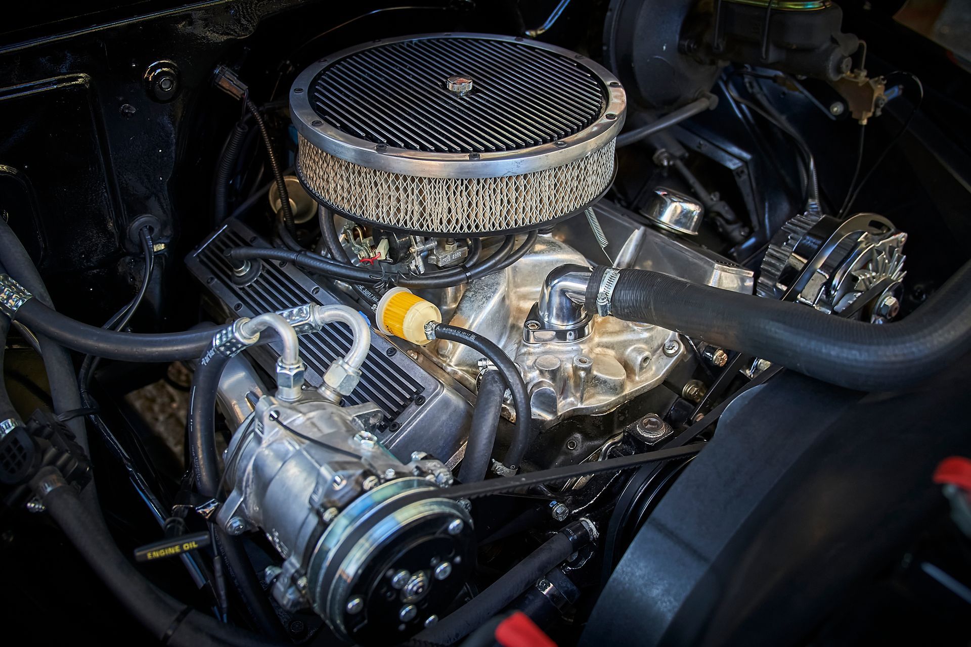 A close up of a car engine with a air filter.