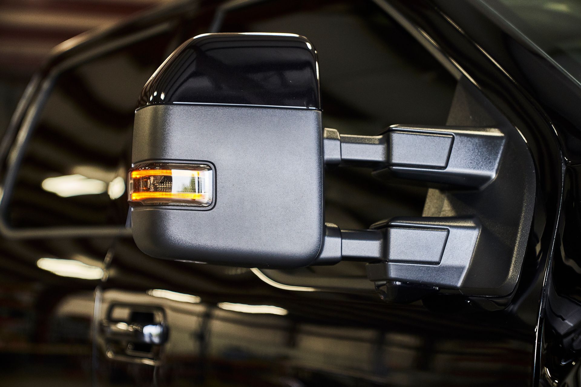 A close up of a side view mirror on a black car