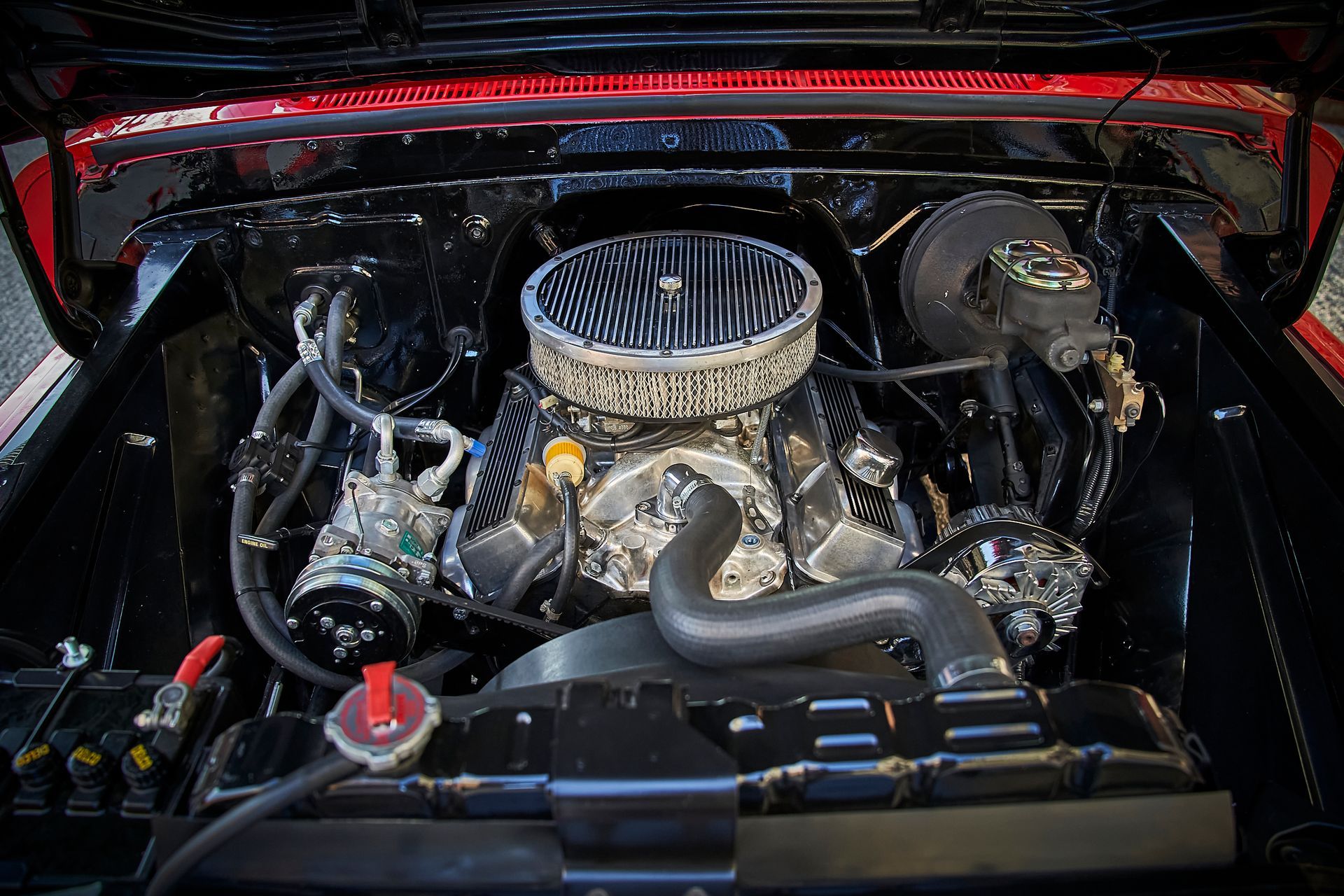 A close up of a car engine with the hood open.
