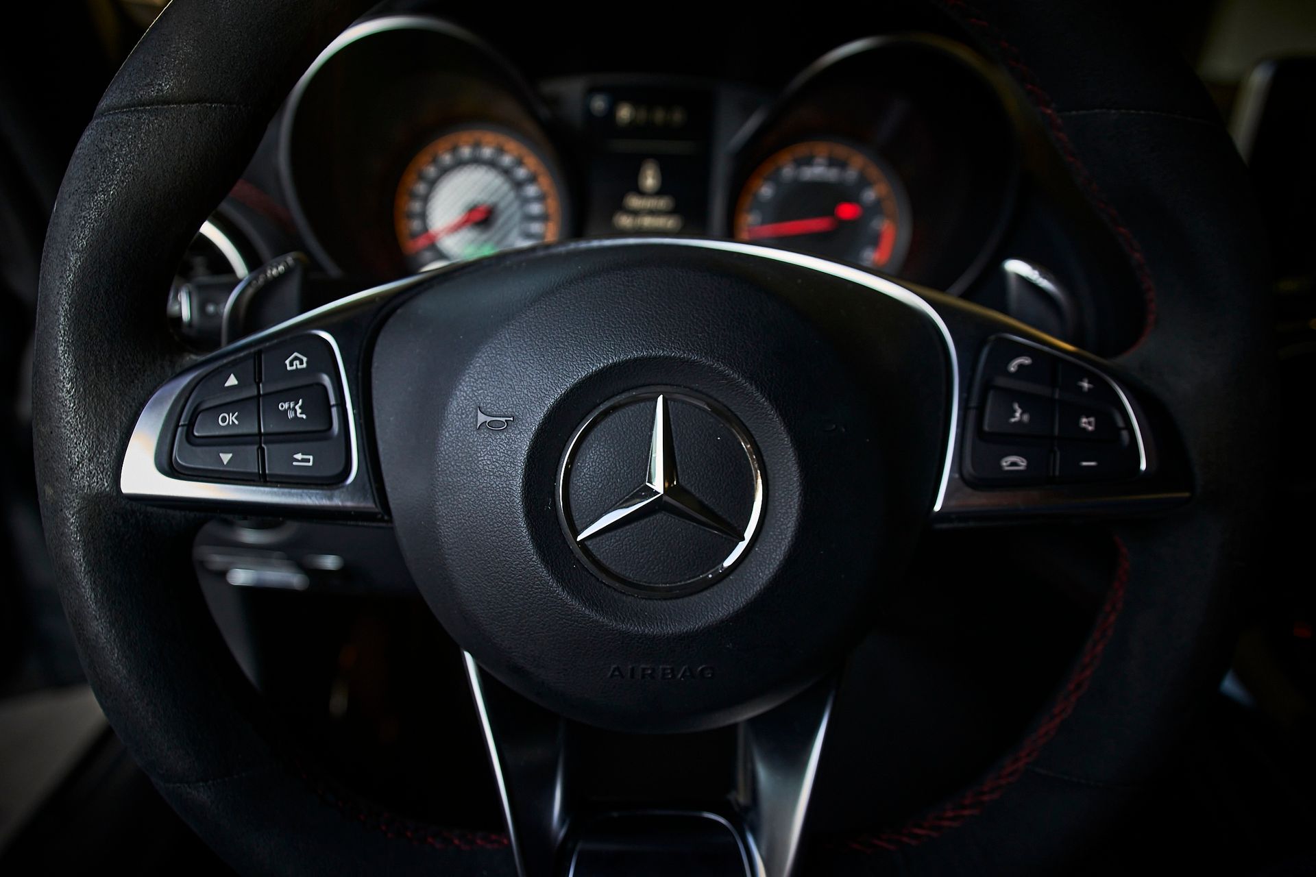 A close up of a mercedes steering wheel with a mercedes logo on it