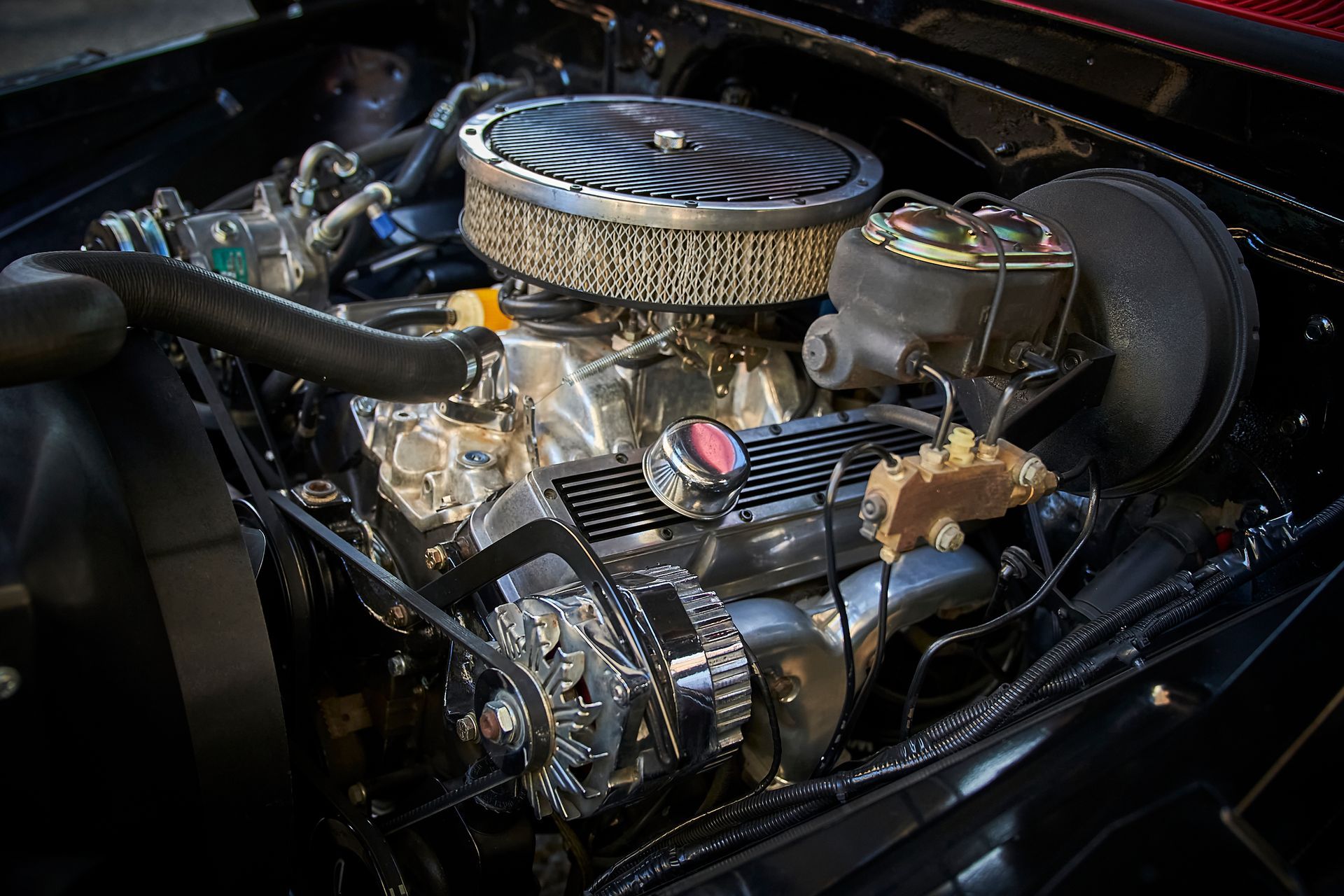 A close up of a car engine with a air filter.
