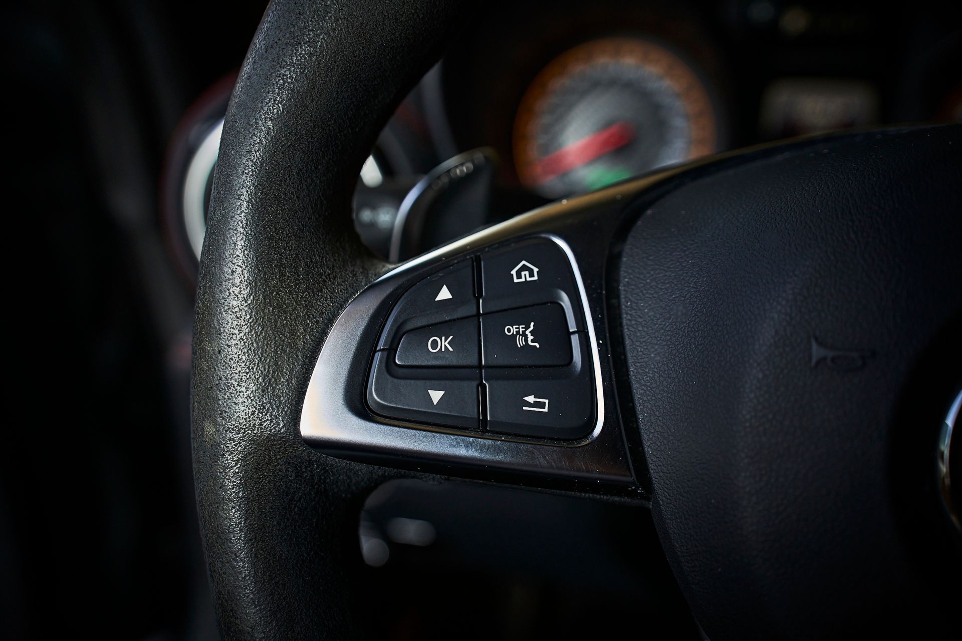 A close up of a steering wheel with buttons on it