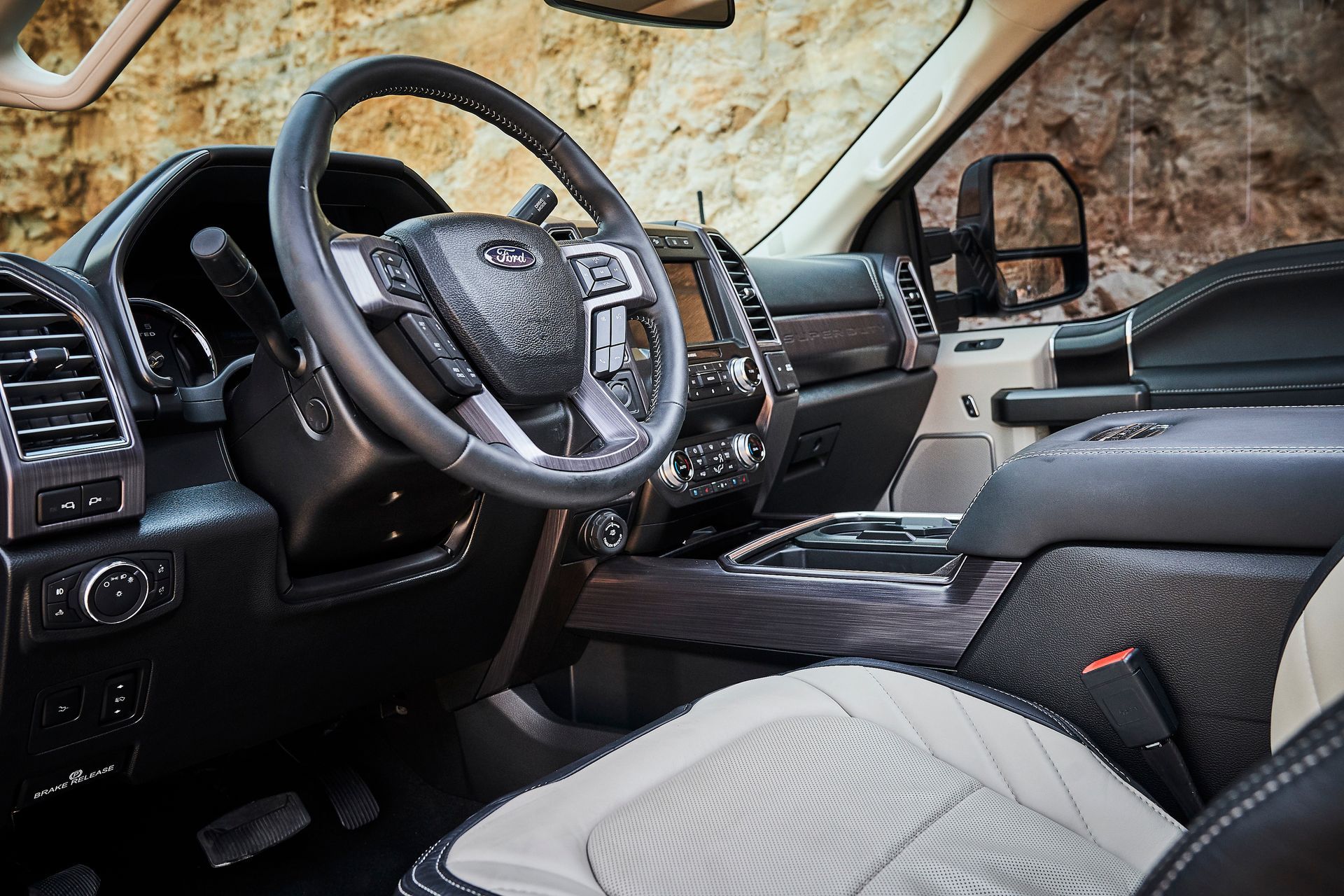 The interior of a ford truck with a steering wheel and seats.