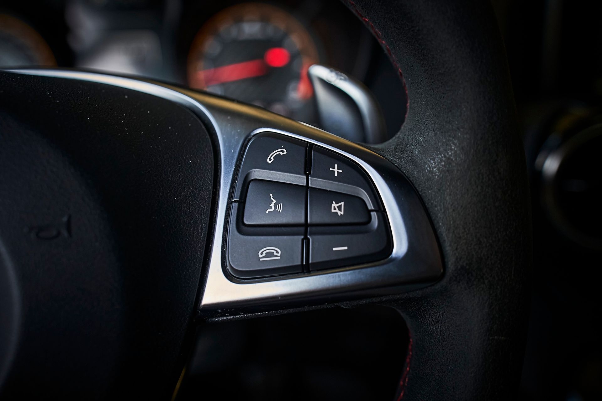 A close up of a steering wheel with a few buttons on it