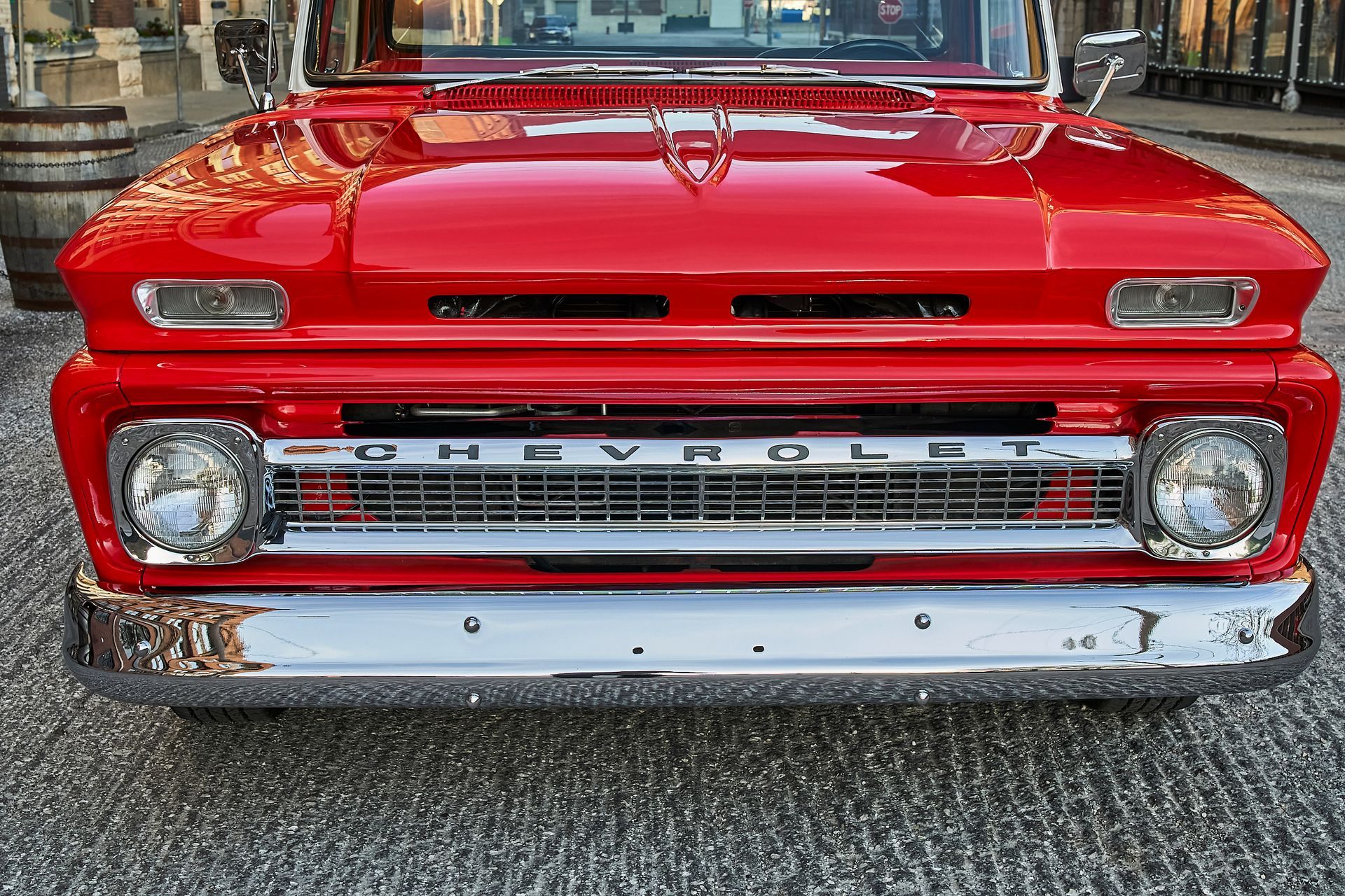 A red chevrolet truck is parked on a gravel road.