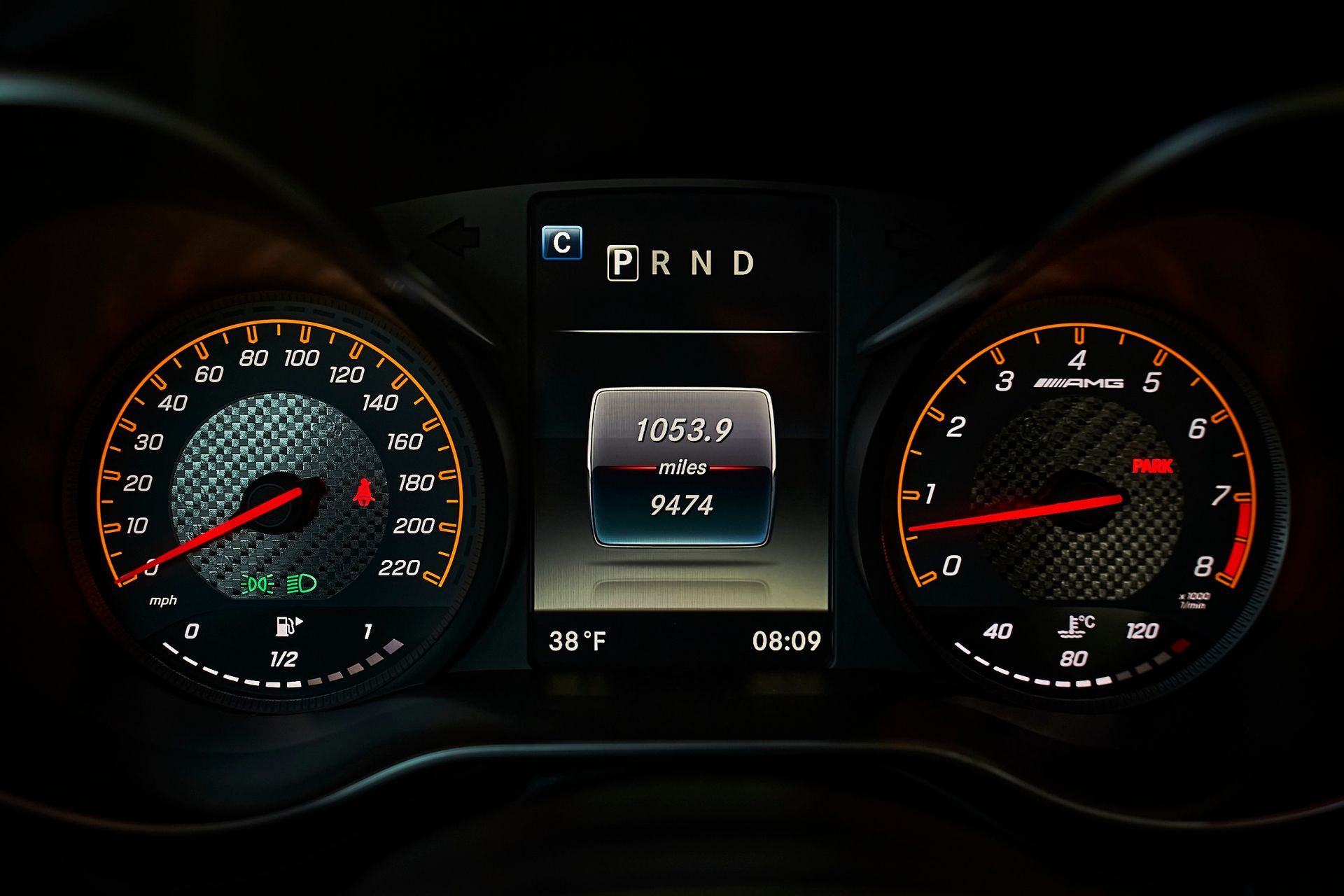 A car dashboard with a speedometer and a tachometer