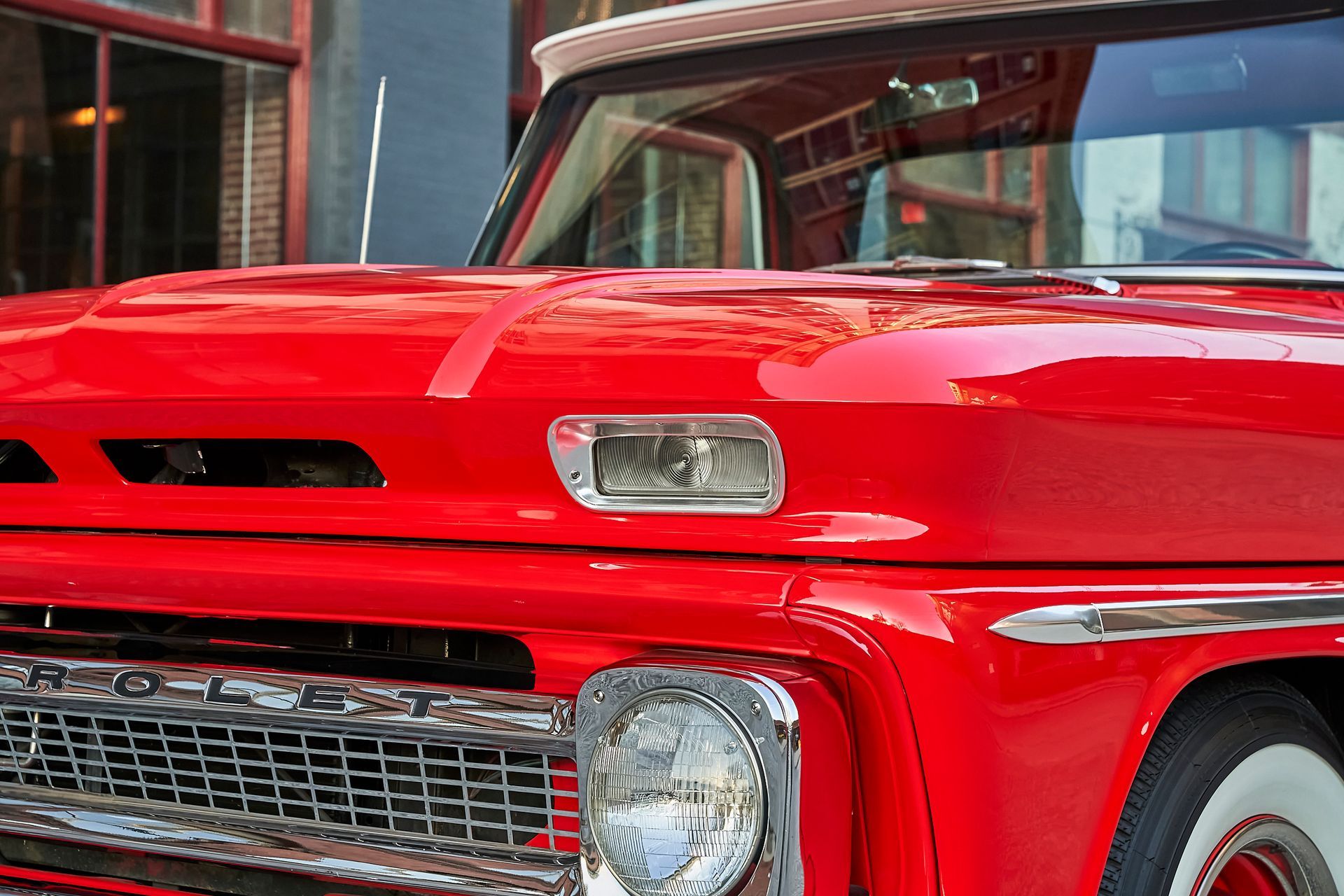 A red truck is parked in front of a building.