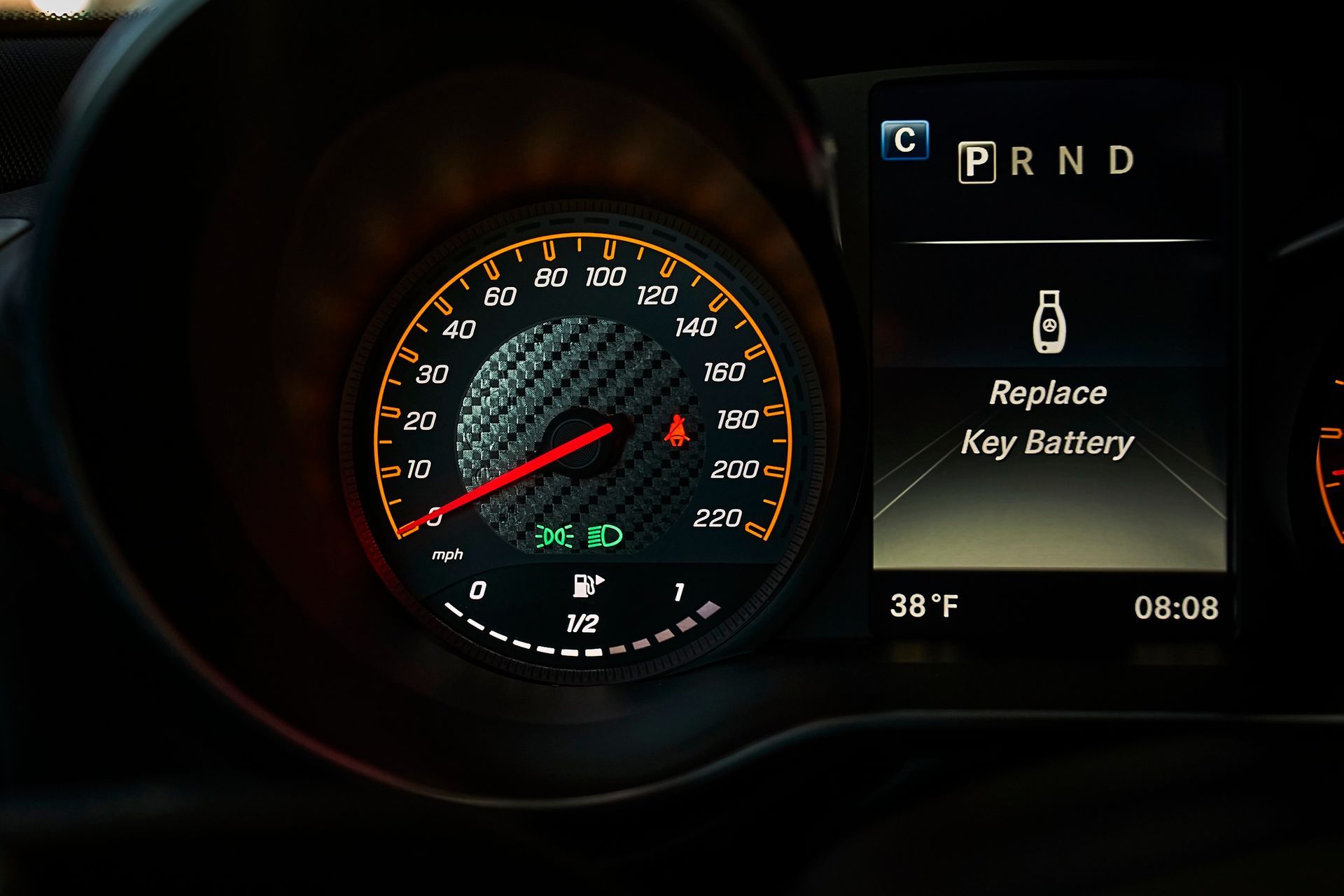 A close up of a car dashboard that says replace key battery
