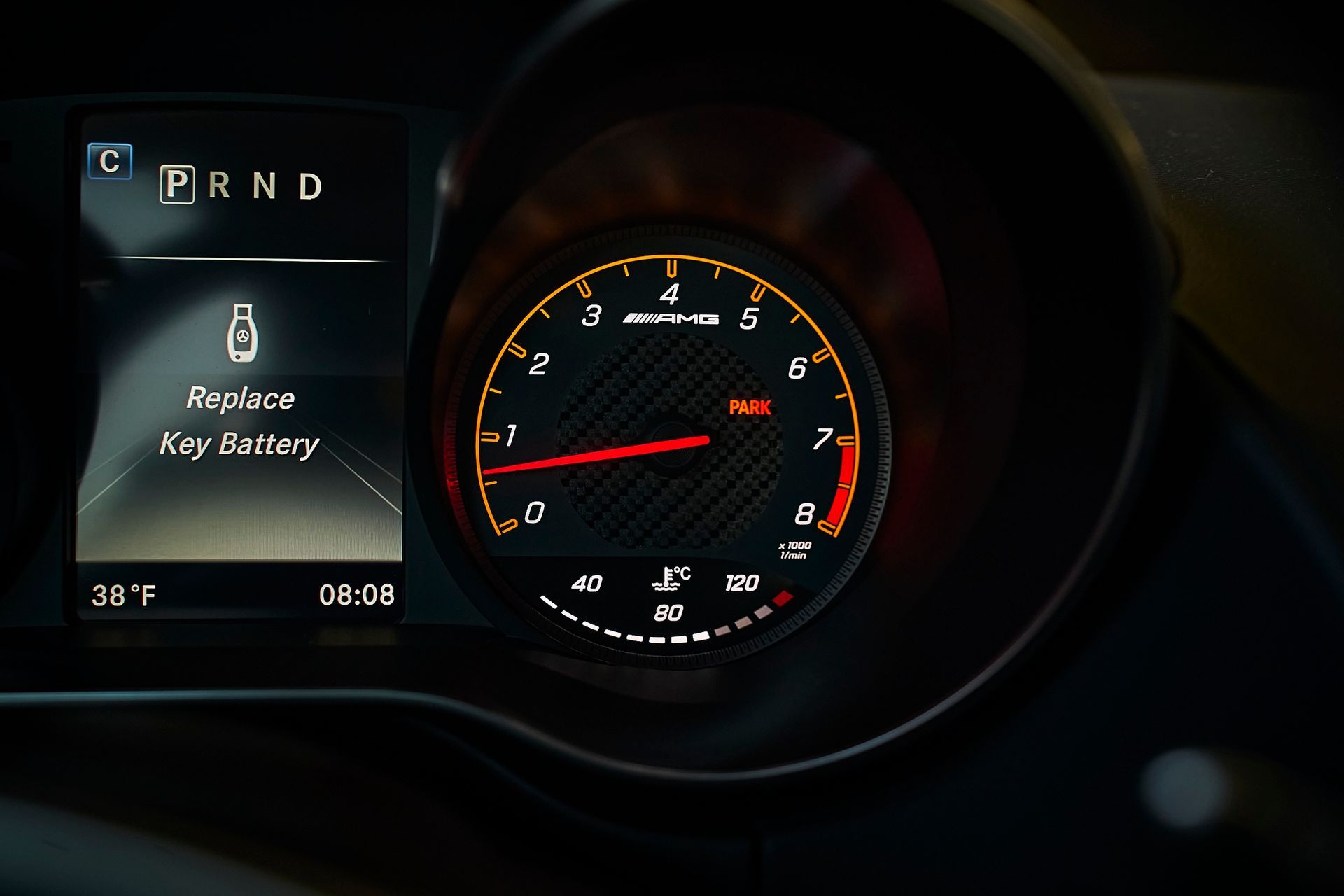 A close up of a car dashboard that says replace key battery