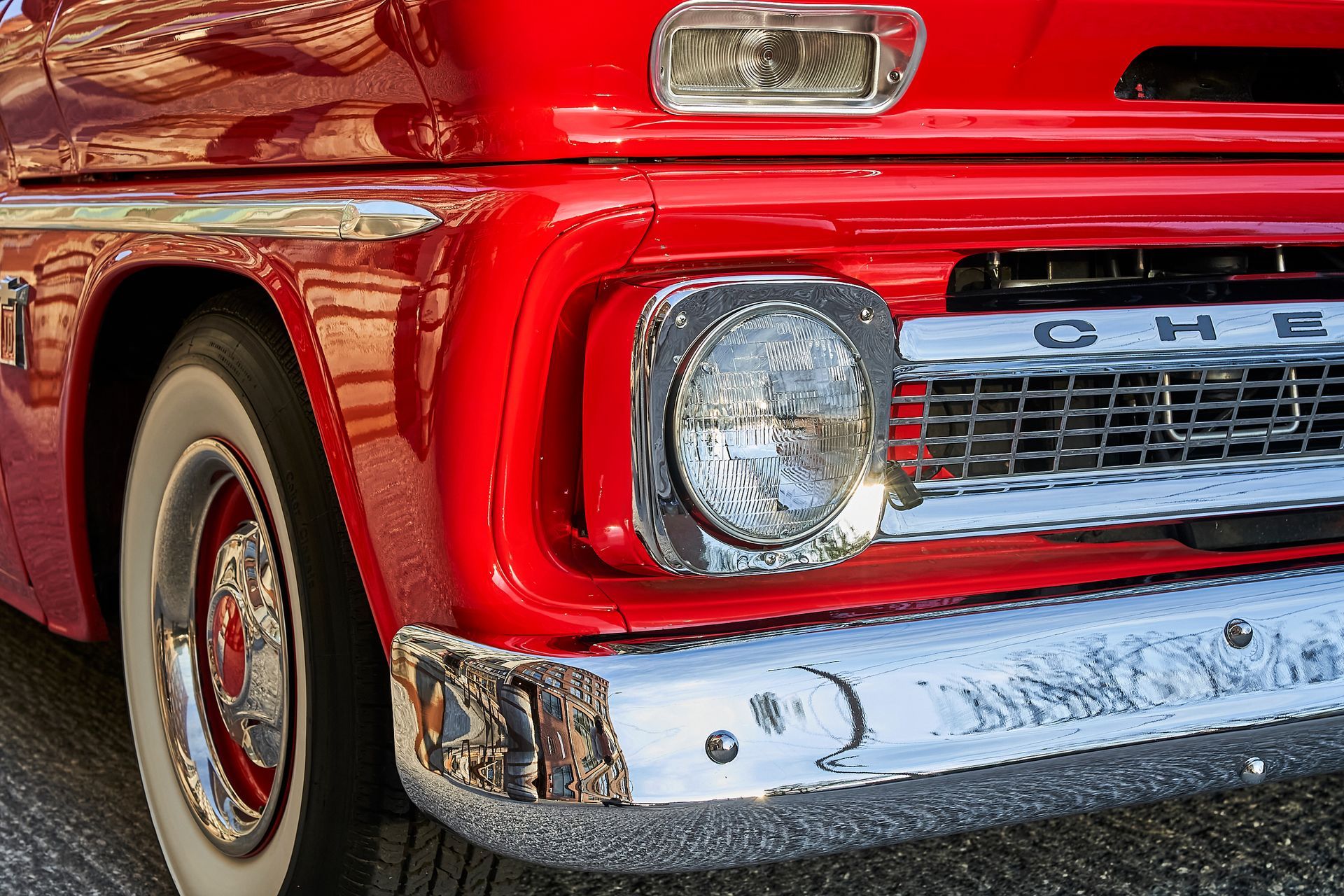 A red chevrolet truck is parked on the side of the road.
