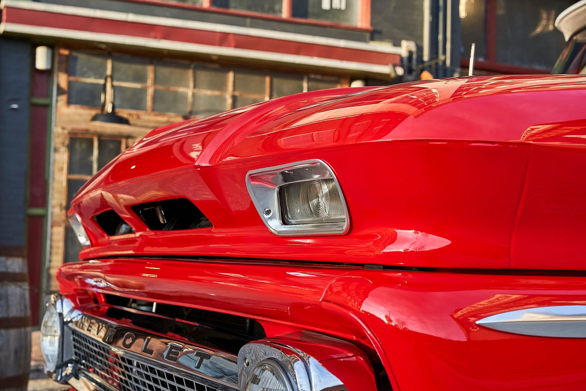 A red truck is parked in front of a building.