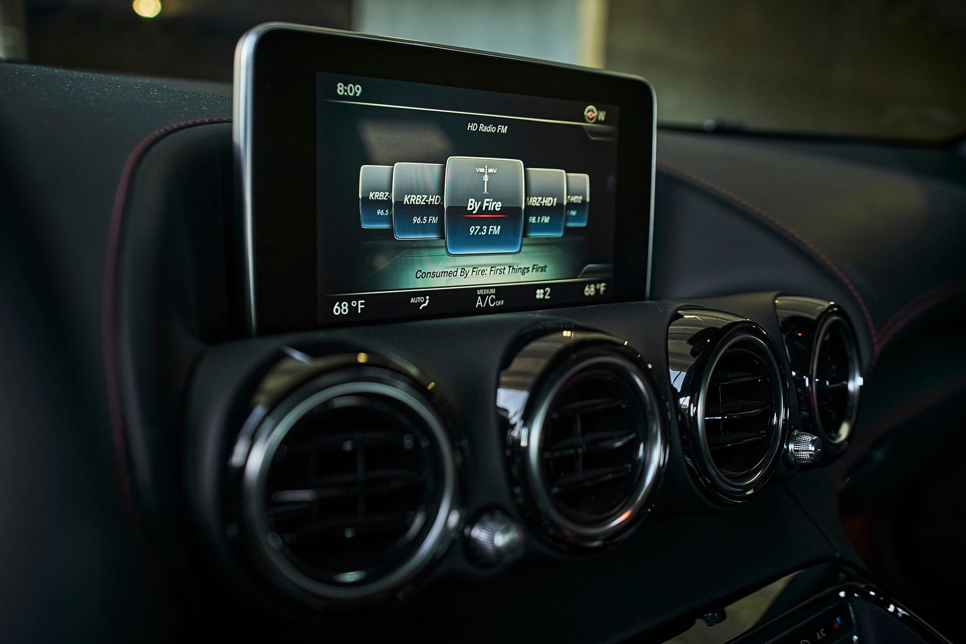 A car dashboard with a touchscreen and air vents
