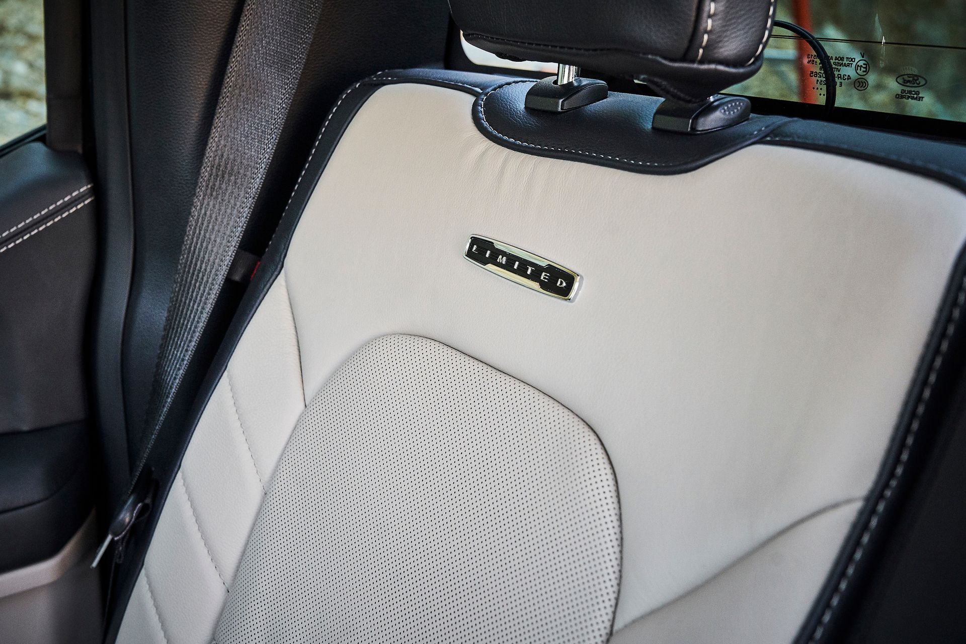 A close up of a car seat with a black headrest
