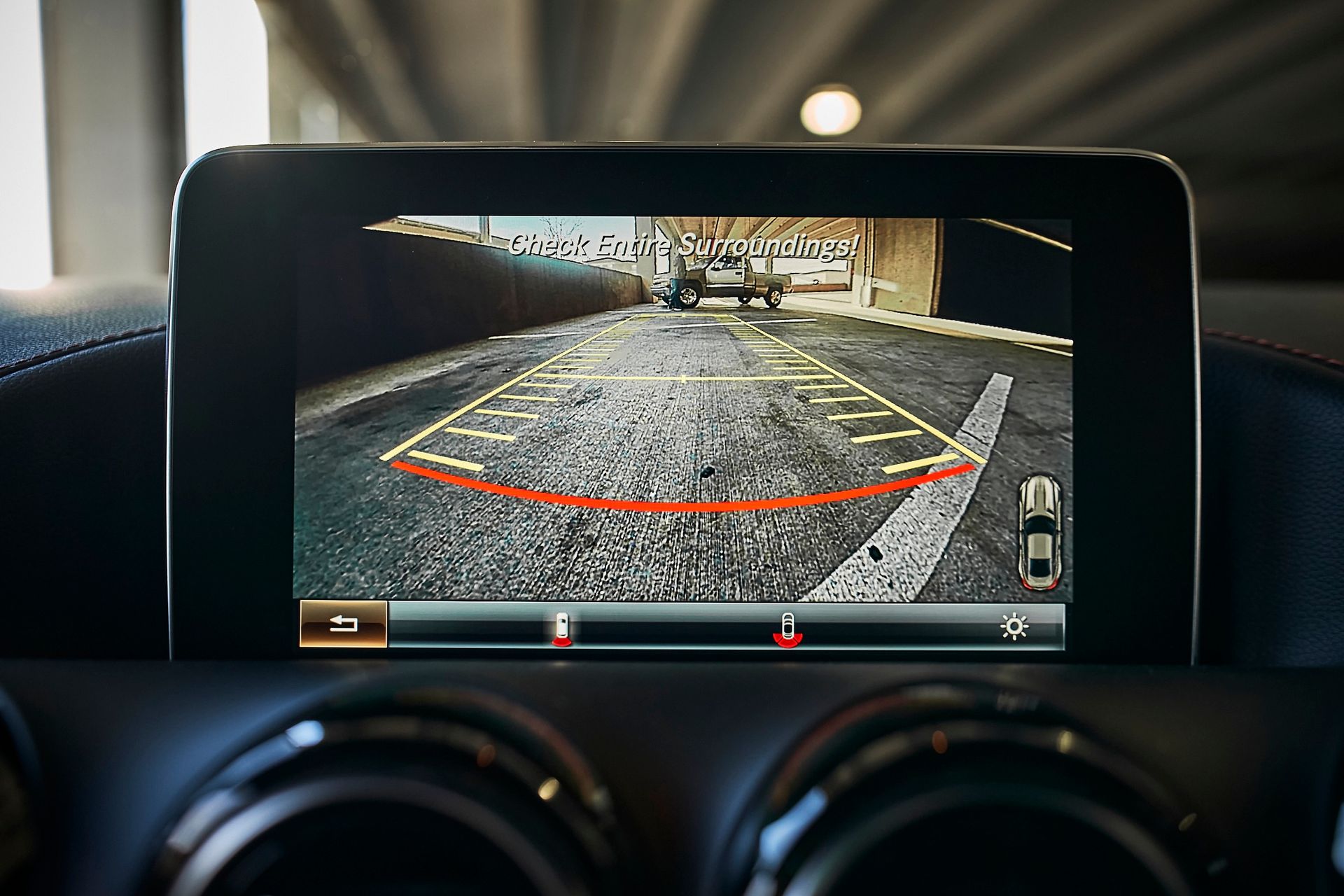 A rear view camera is displayed on the dashboard of a car.