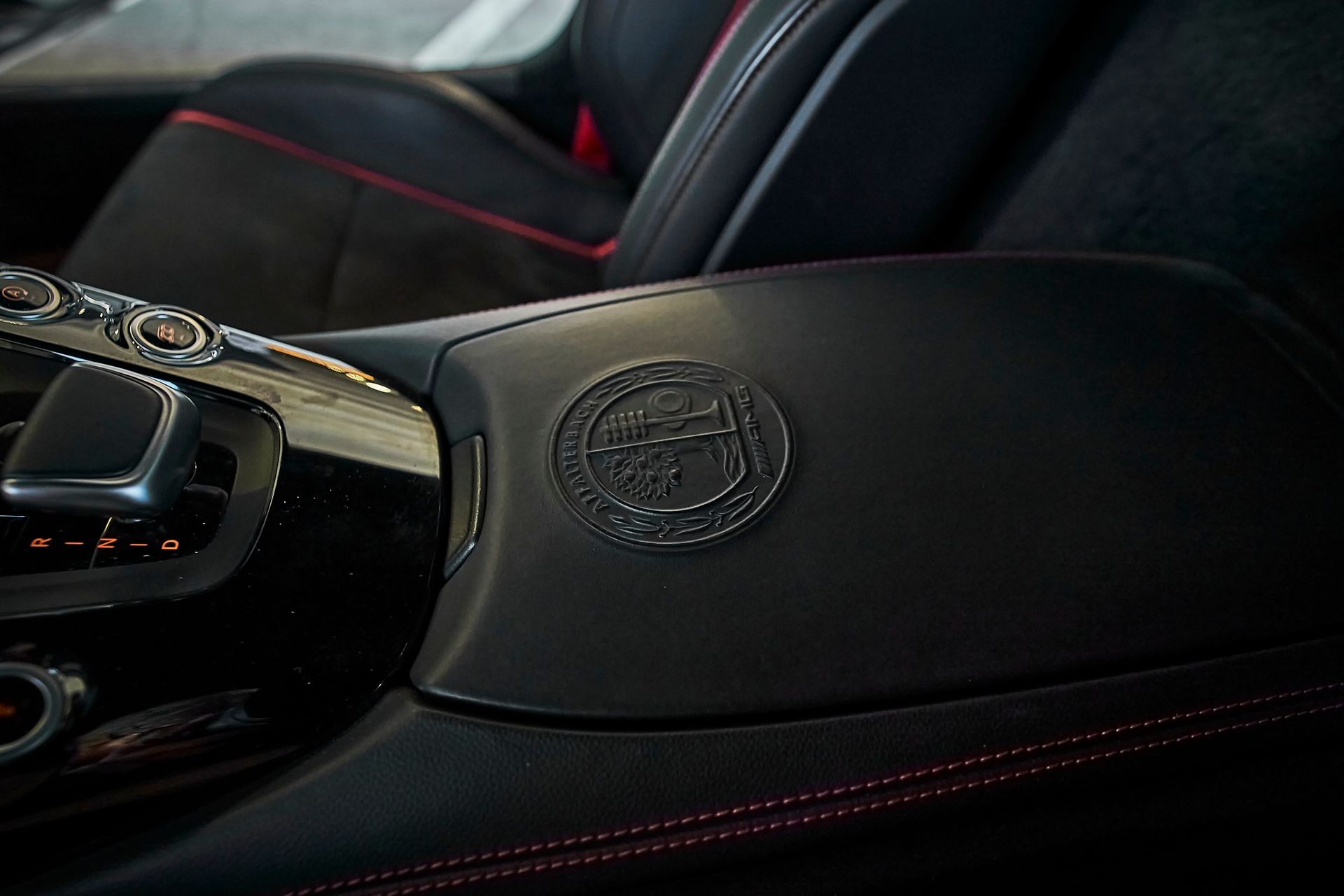 A close up of the arm rest of a car with a logo on it.