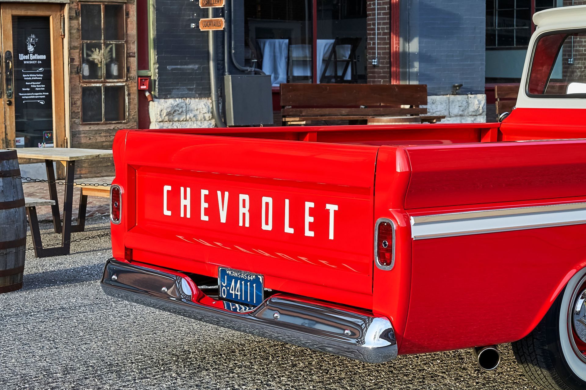 A red chevrolet truck is parked in front of a building