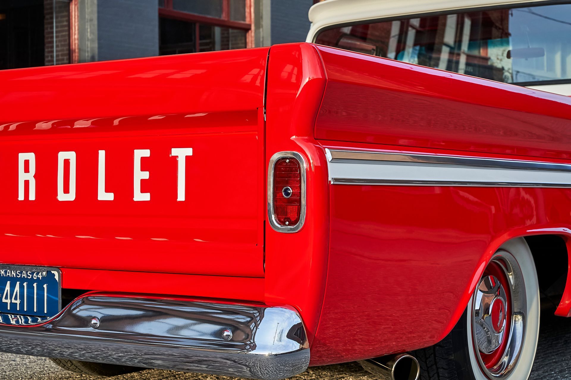 A red chevrolet truck is parked in front of a building