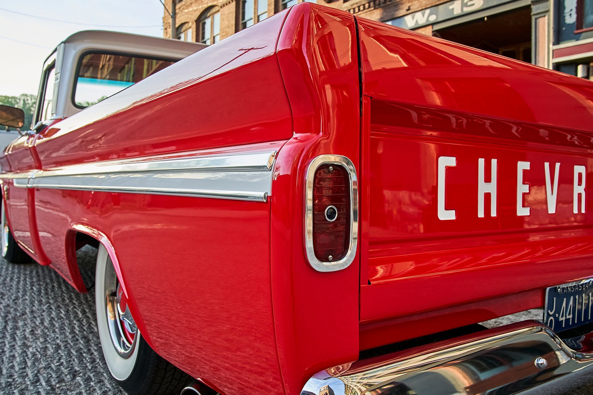 A red chevy truck is parked in front of a building