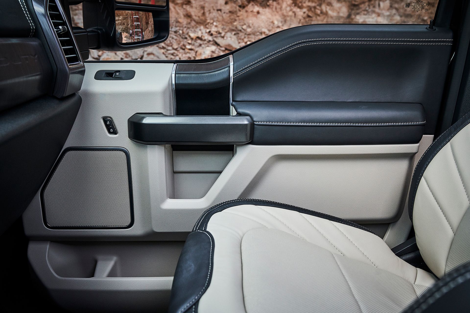 A close up of a car door with a speaker in it.