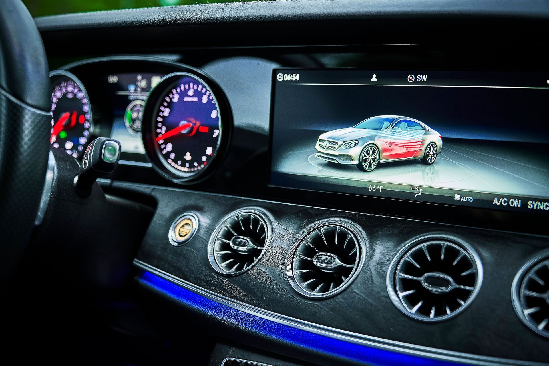 The dashboard of a car with a picture of a car on the screen.
