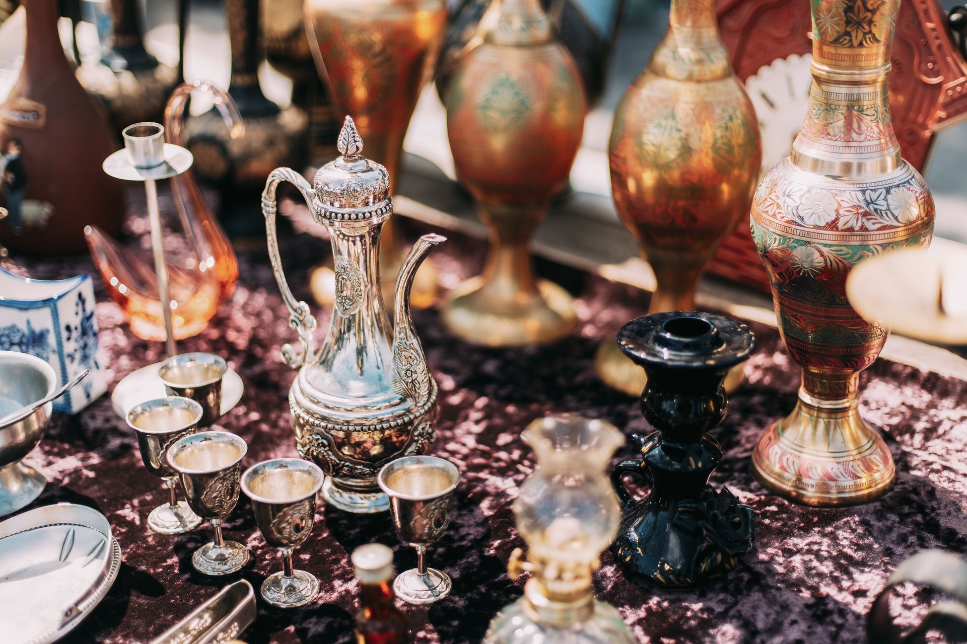 A table topped with a variety of vases and candles.