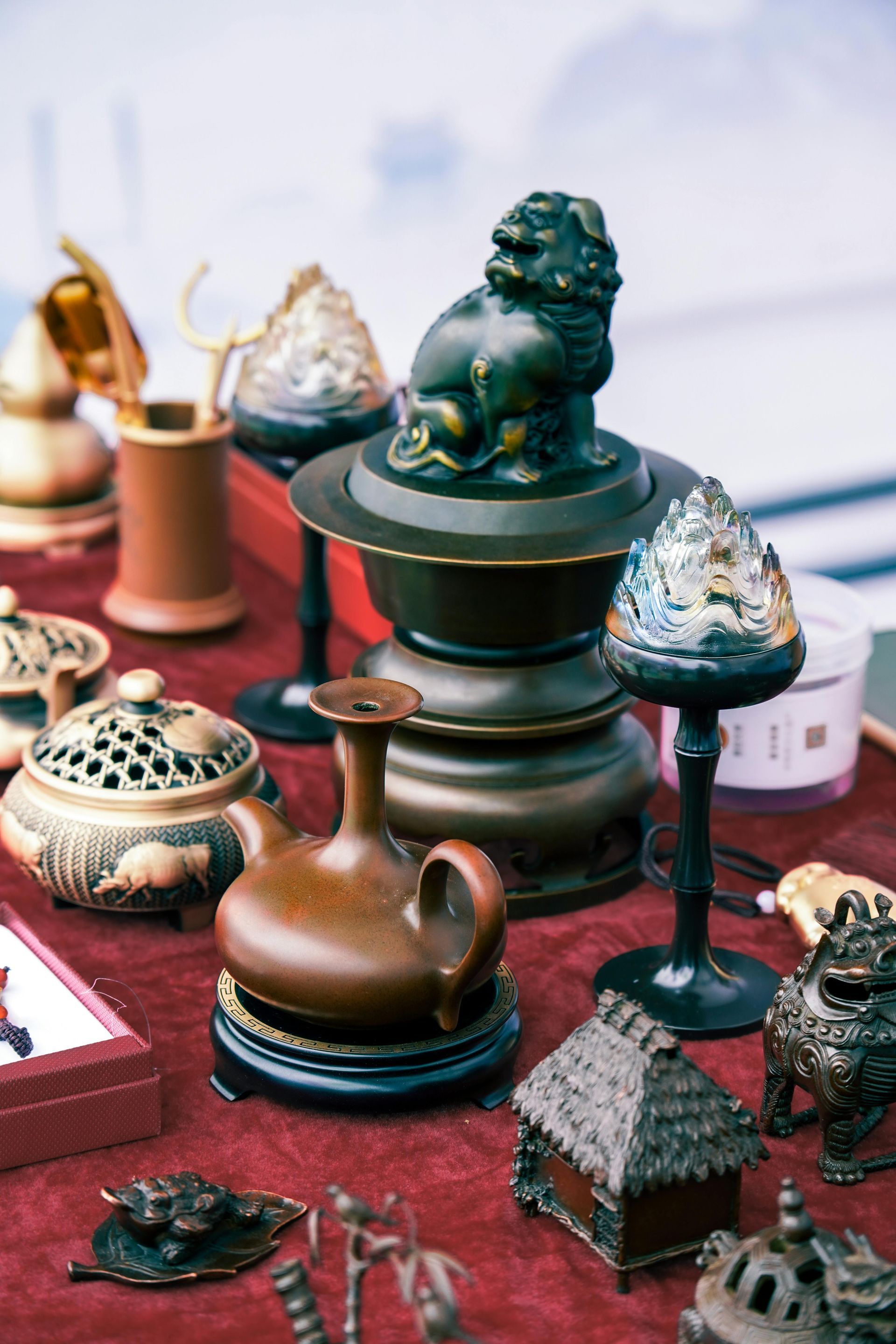 A table topped with a variety of antique items including a statue of a lion.