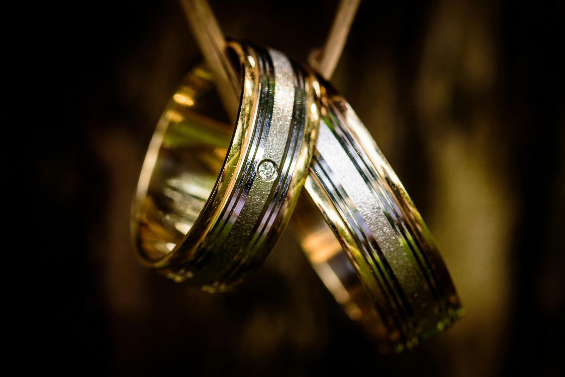 A close up of two wedding rings hanging on a stick.