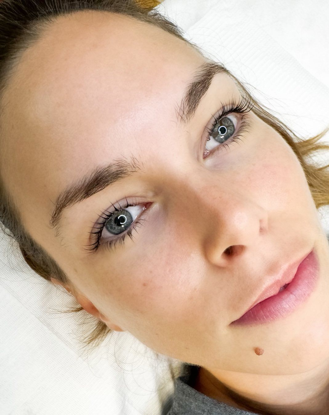 Woman with blue eyes, light skin, and brown eyebrows looking at the camera. She's in a well-lit setting.