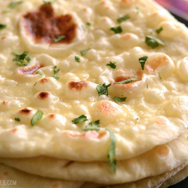 Un gros plan d'une pile de pain naan sur une table.