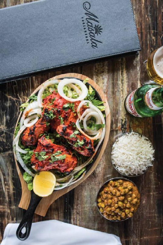 Une assiette de nourriture est posée sur une table en bois à côté d'un menu.