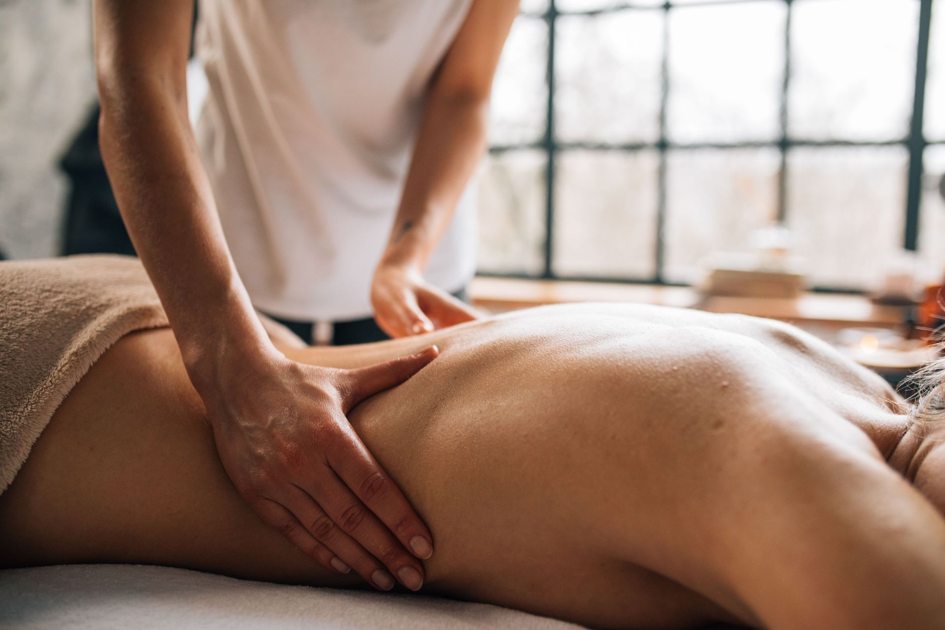 Massage therapist pressing a client's back during a therapeutic massage session