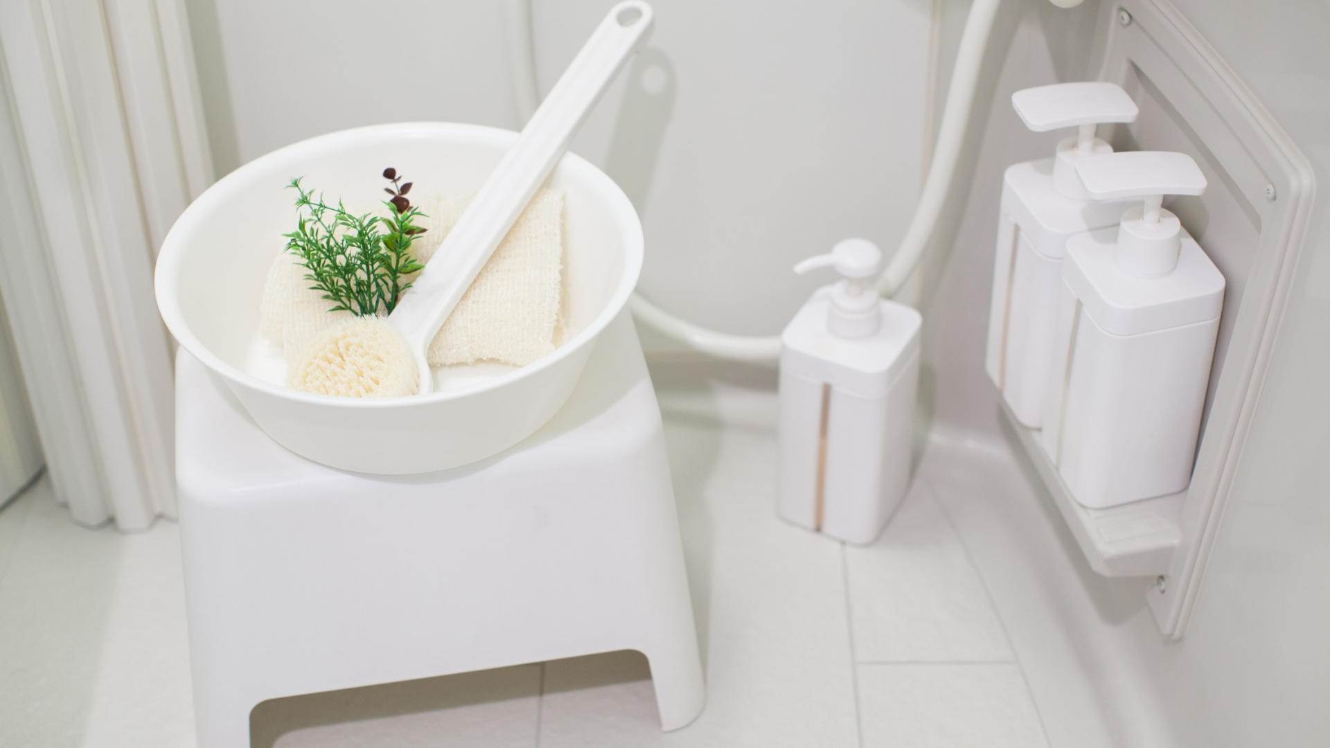 White bathroom sink with basin, brush, soap dispenser, and organized toiletries on a shelf