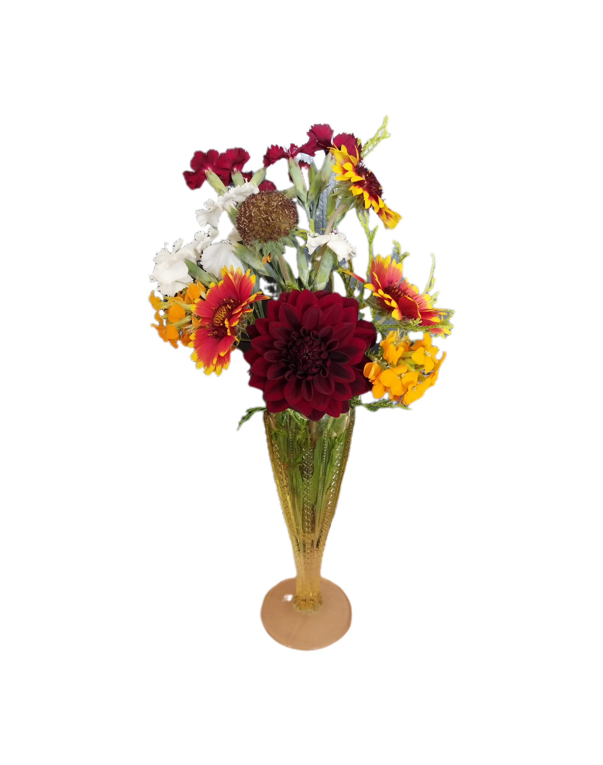 A vibrant bouquet of deep red, orange, white, and yellow flowers in a decorative, gold-tinted fluted glass vase.