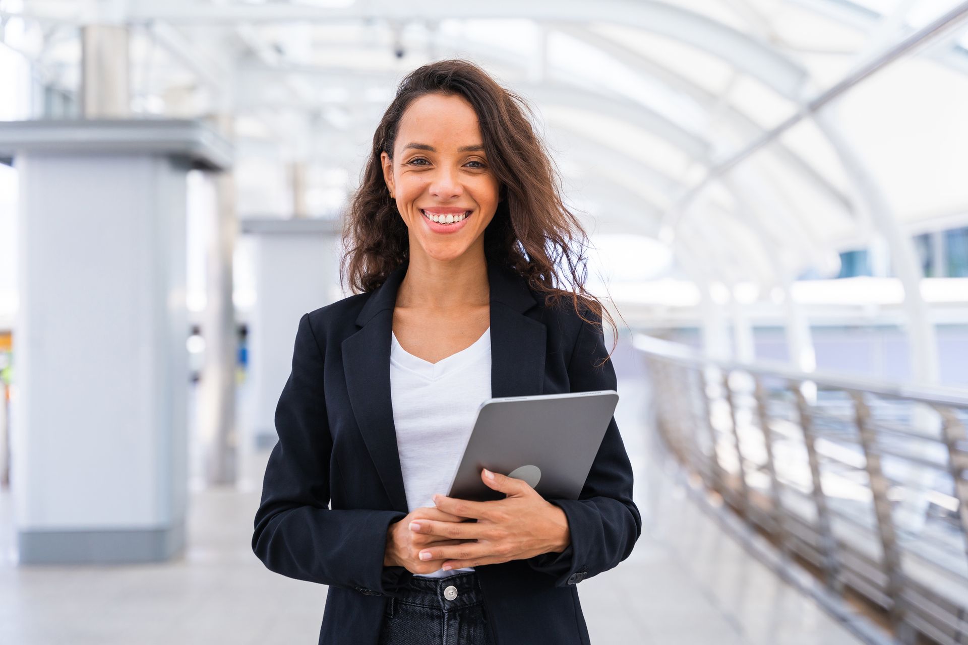 A woman is holding a tablet in her hands and smiling. A woman is holding a tablet in her hands and smiling.