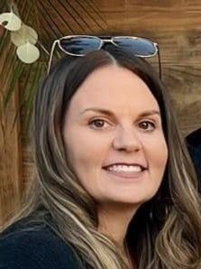 A woman with brown hair is smiling