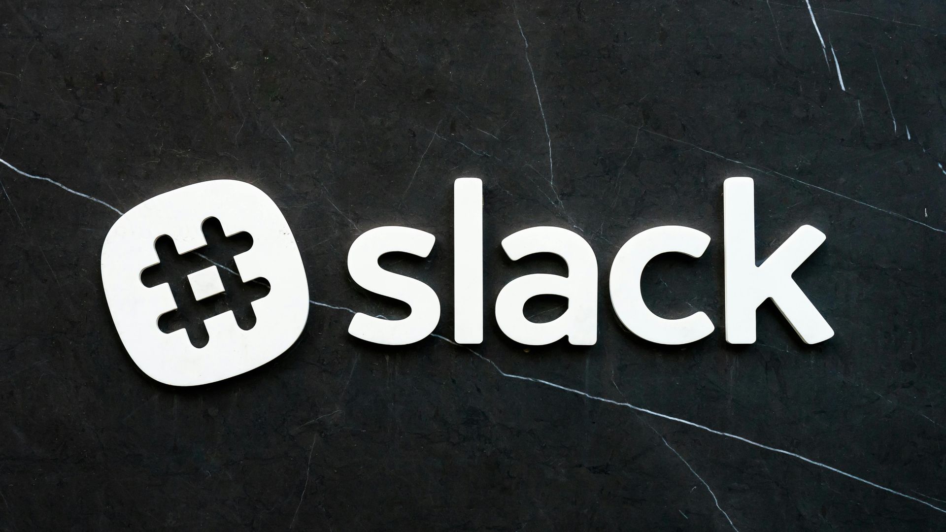 Slack logo with a white hashtag symbol next to the word 