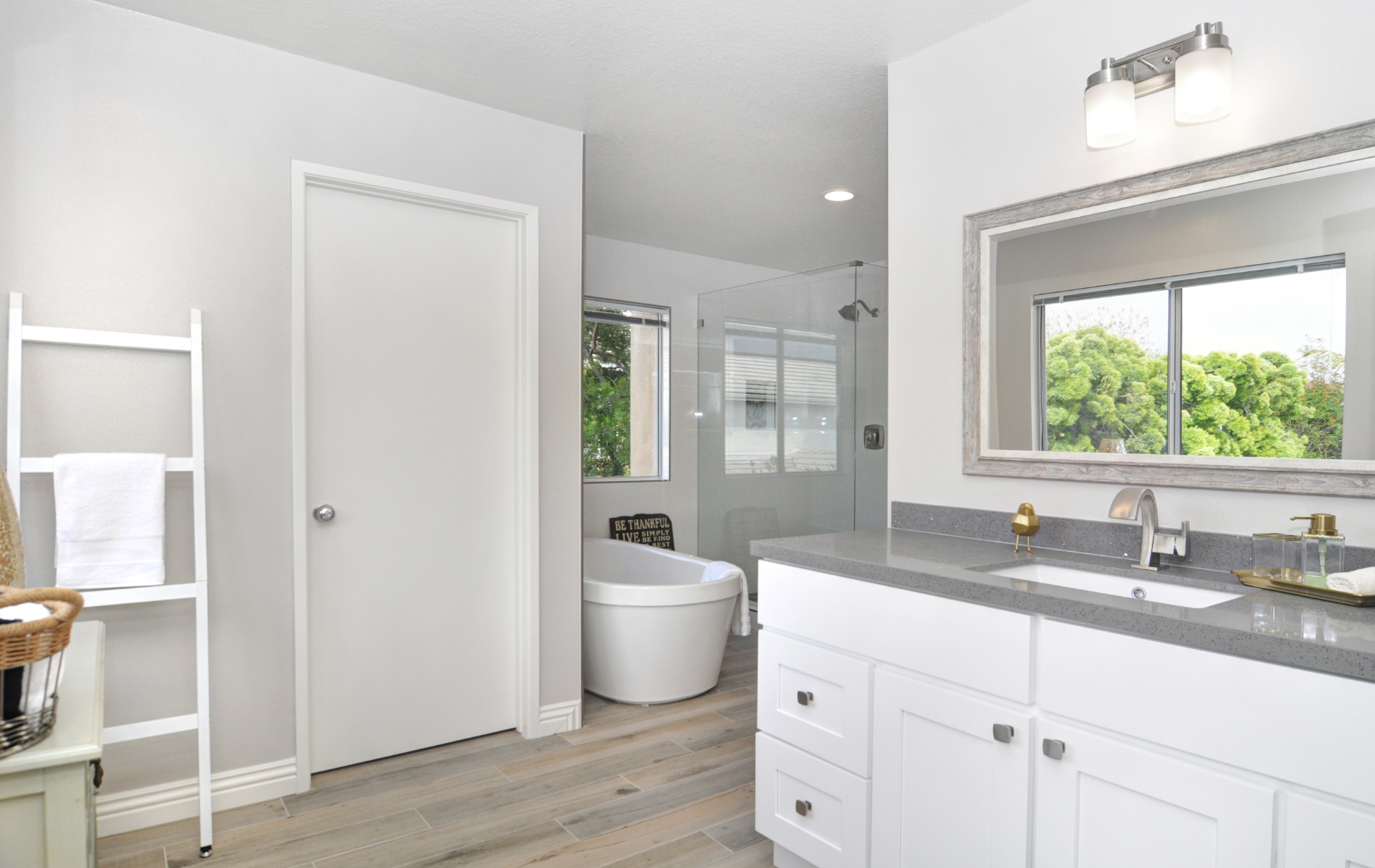 A bathroom with a tub , sink and mirror.