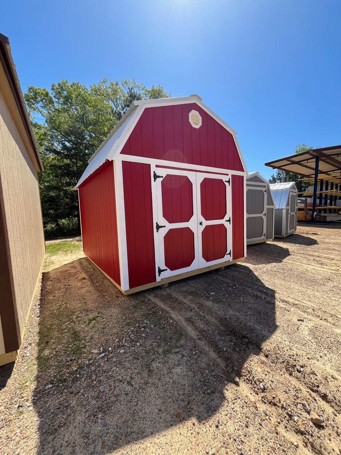 A gray barn with a black roof and a porch