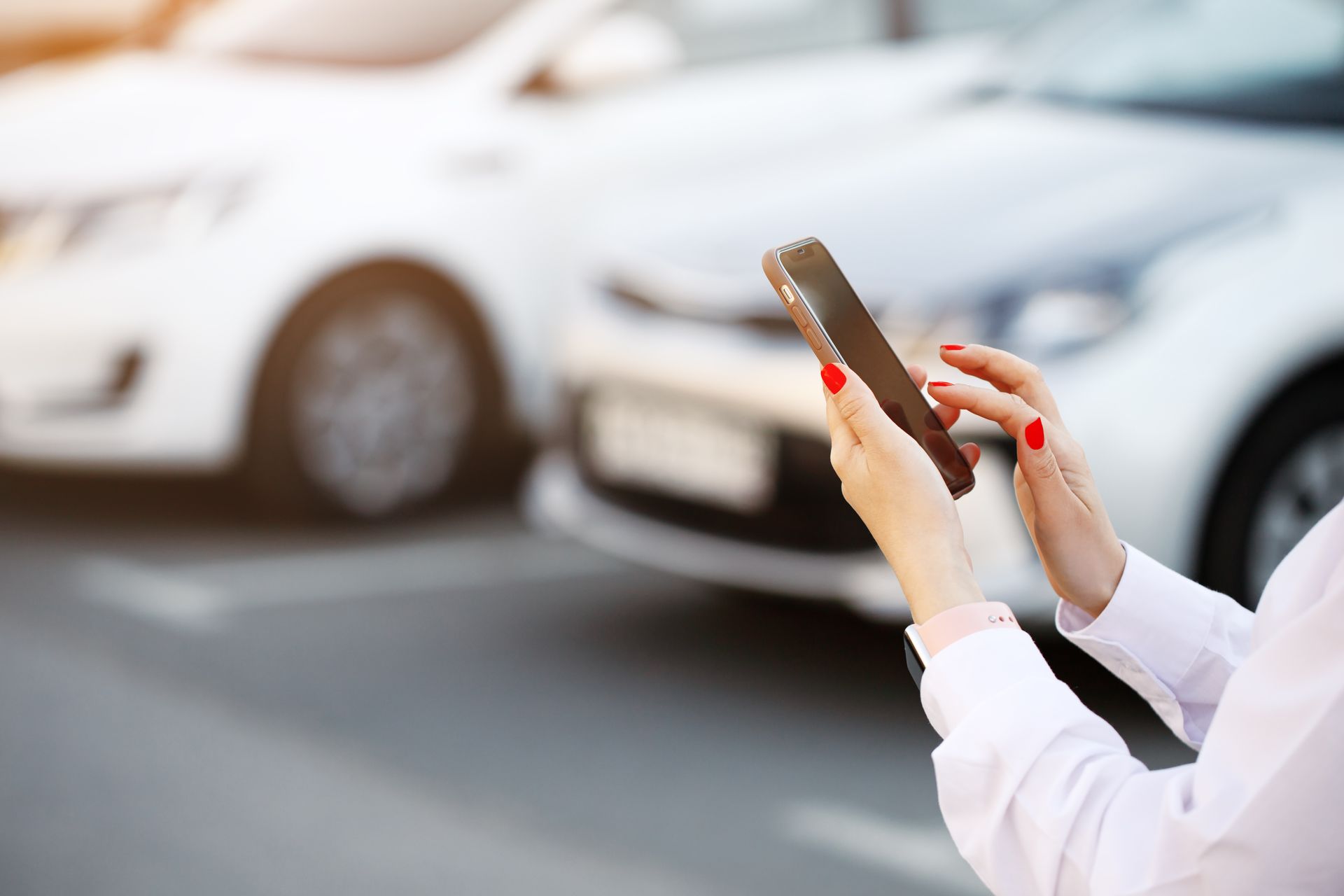 woman using her phone near a vehicle