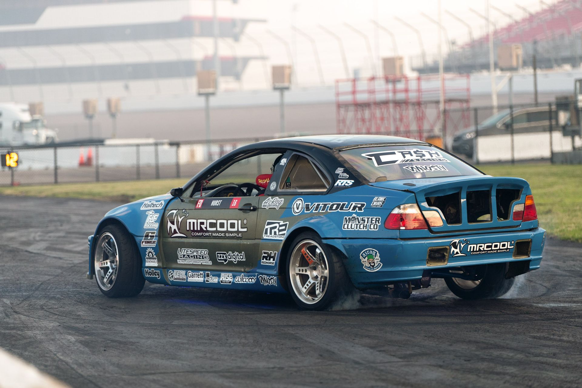 A blue car is drifting on a race track.