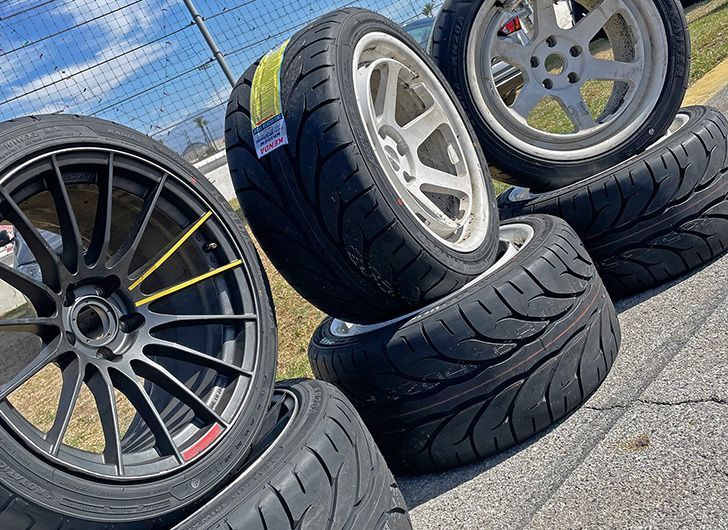 A bunch of tires and wheels are stacked on top of each other.