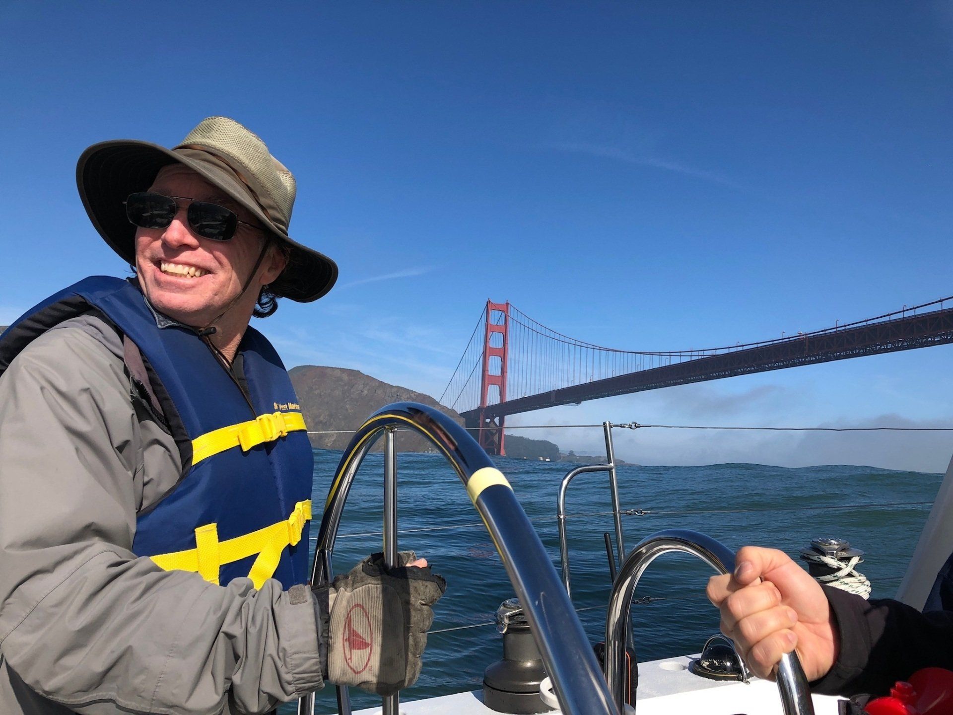 Kirk enjoying a sunny day of sailing with the Golden Gate Bridge in the distance.